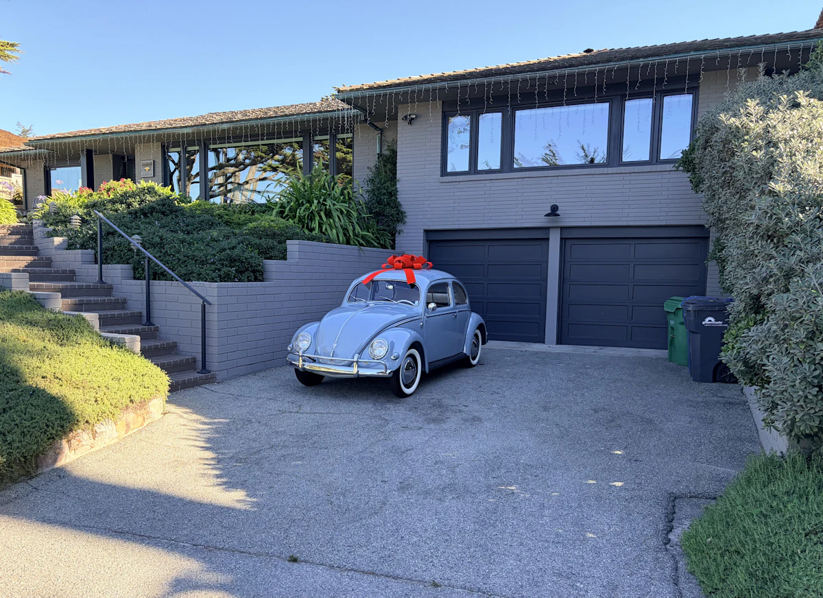 A car with a red bow on the hood, staged as a surprise gift