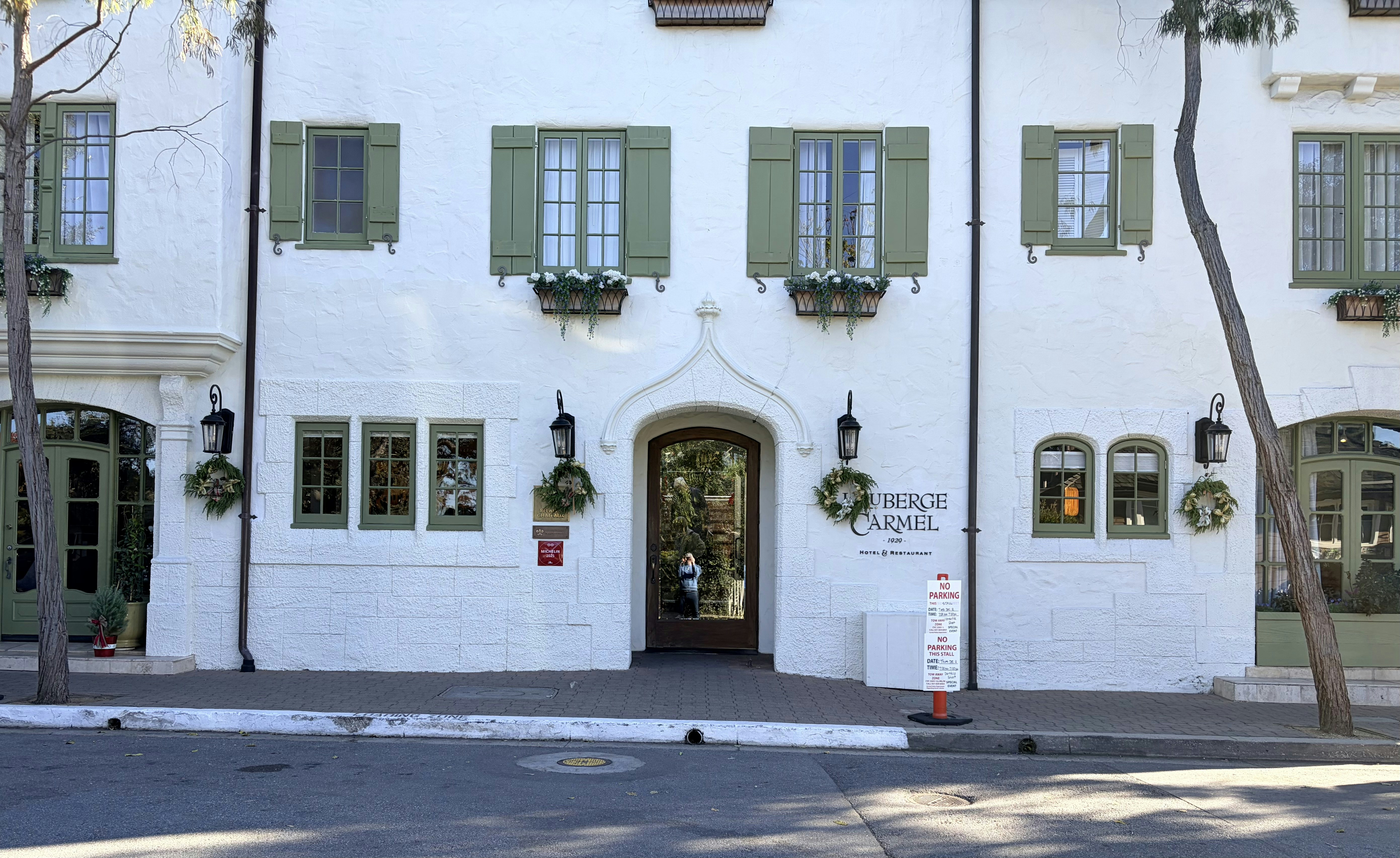 White building with green shutters and arched doorway