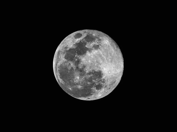 Detailed close-up of the full moon with visible craters against a pitch-black sky