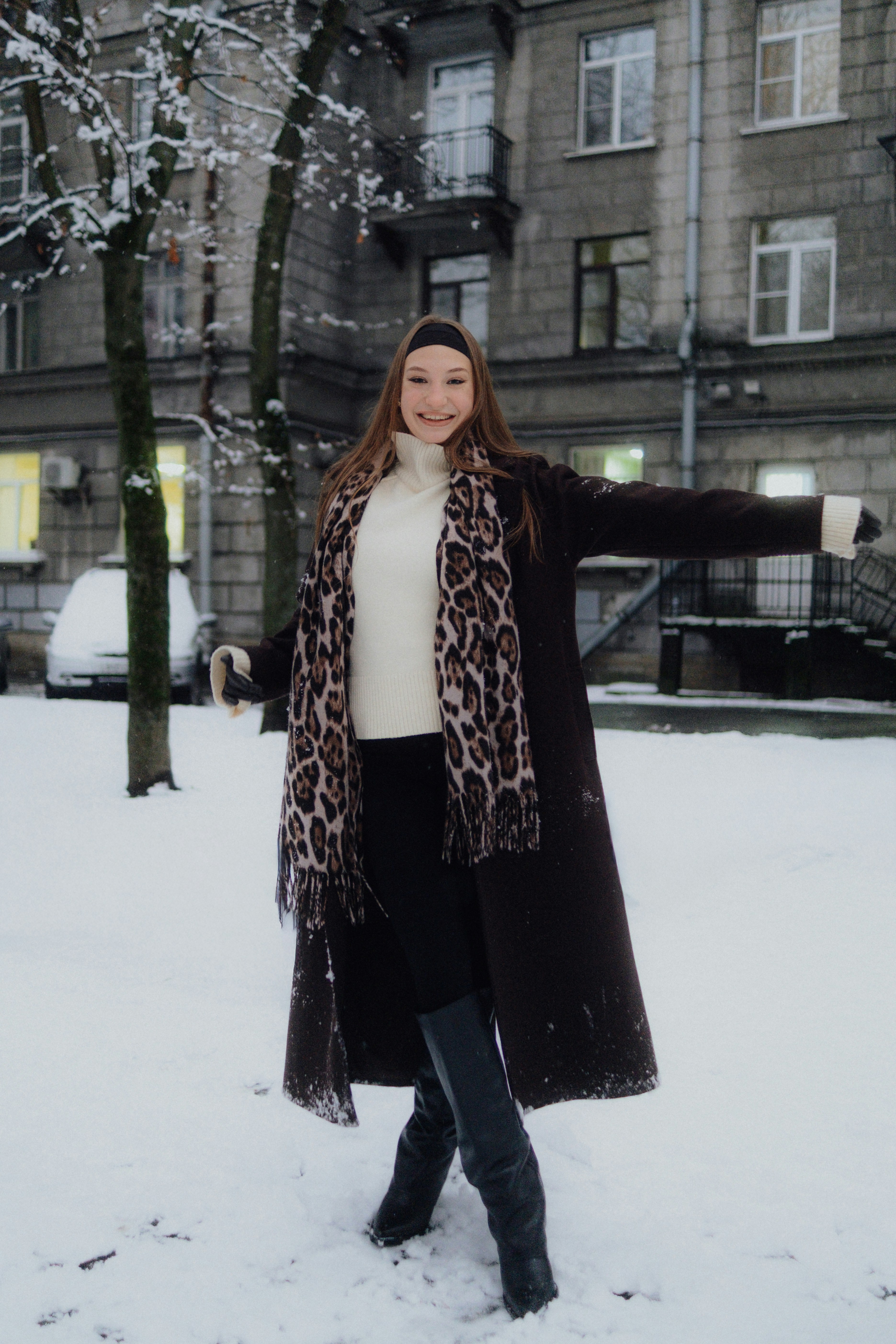 Young woman in winter coat and scarf in snow