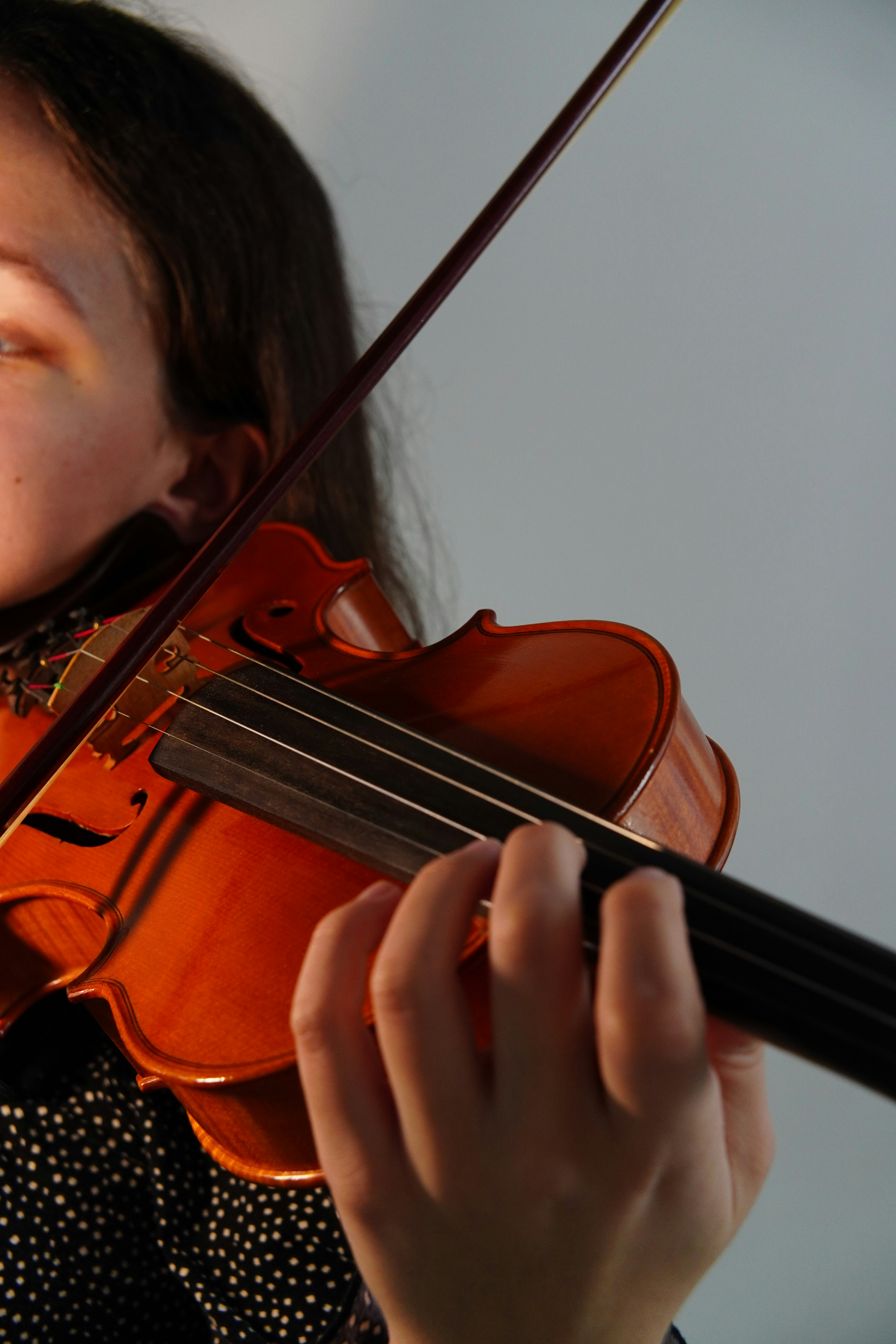 A woman playing a violin with a bow