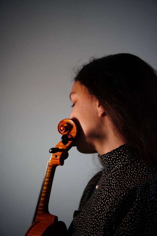 Violinist holding instrument in profile, studio light