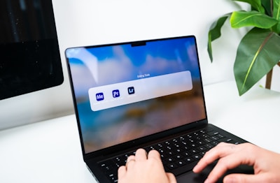 Person typing on a laptop with software icons