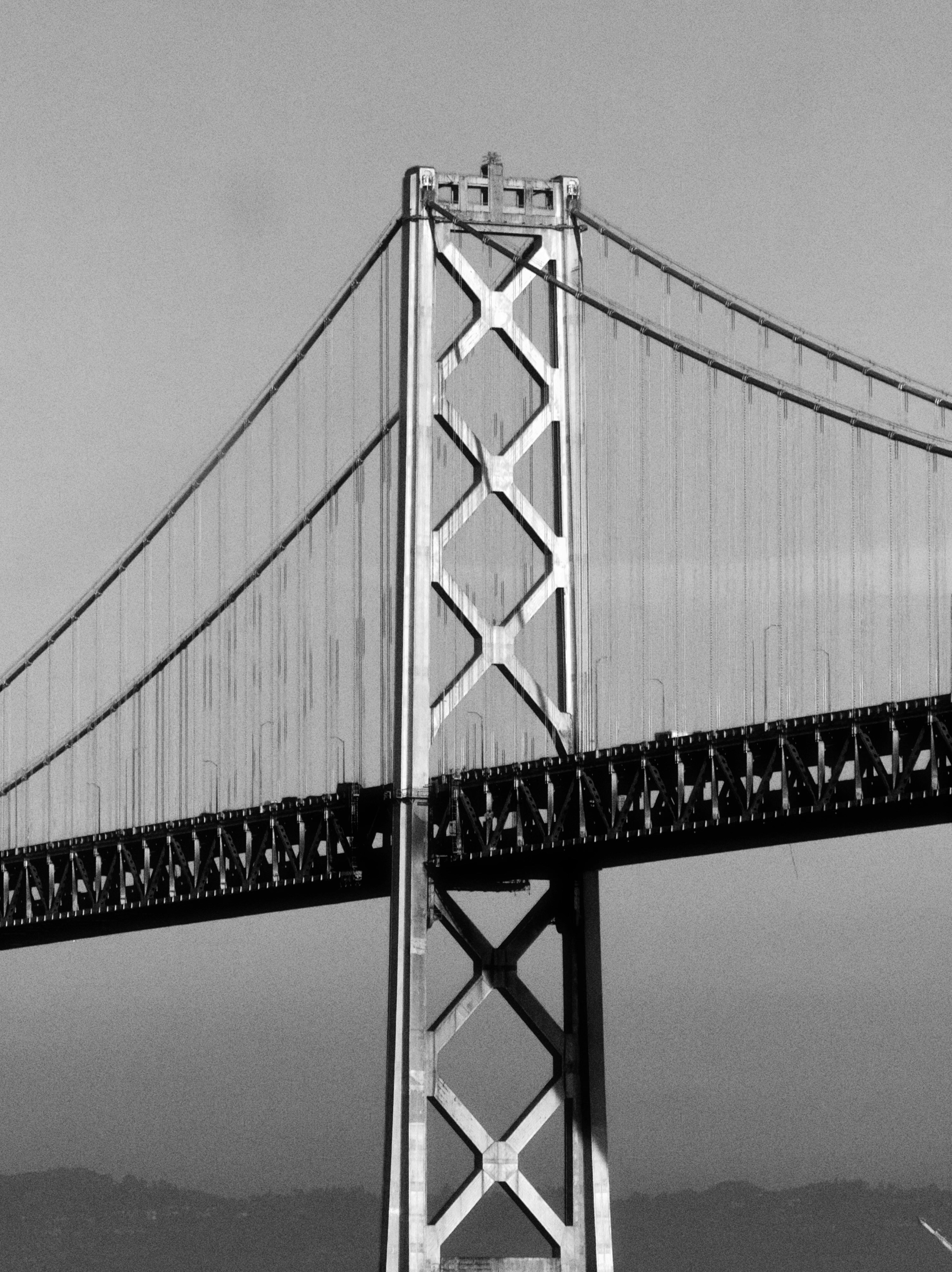 Close-up of a suspension bridge tower against sky.