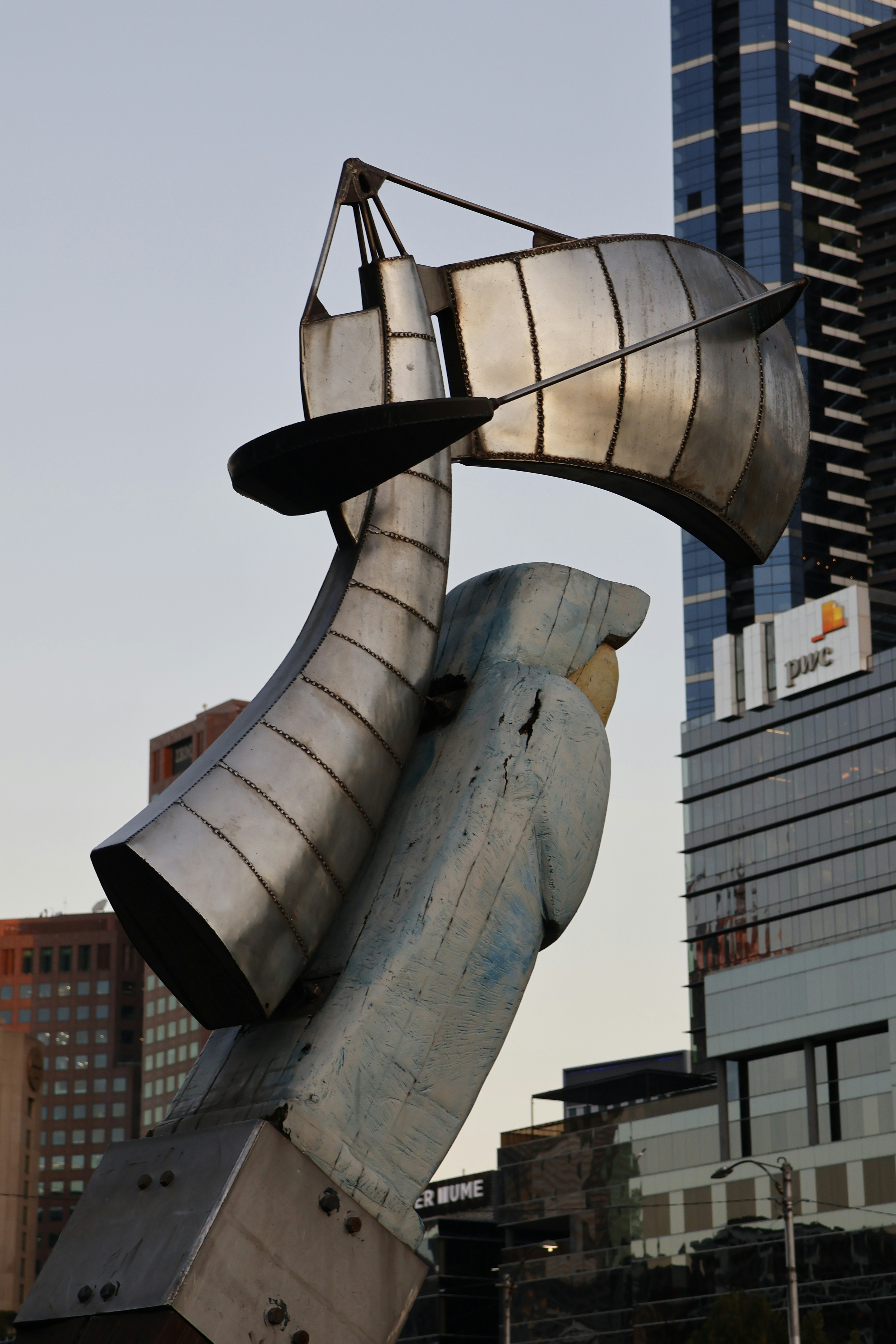 Modern metal sculpture against a city skyline