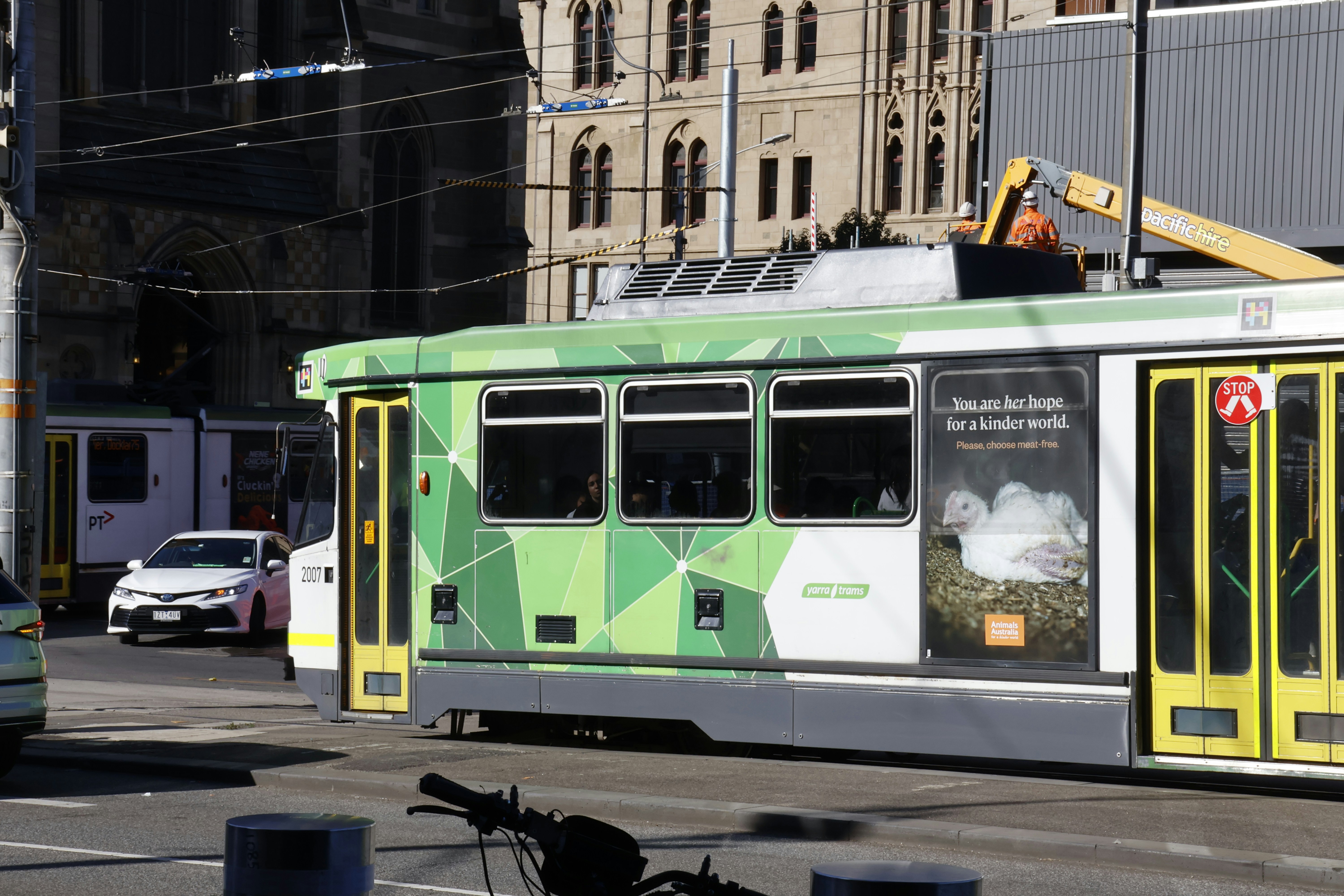 Green tram with geometric patterns on street