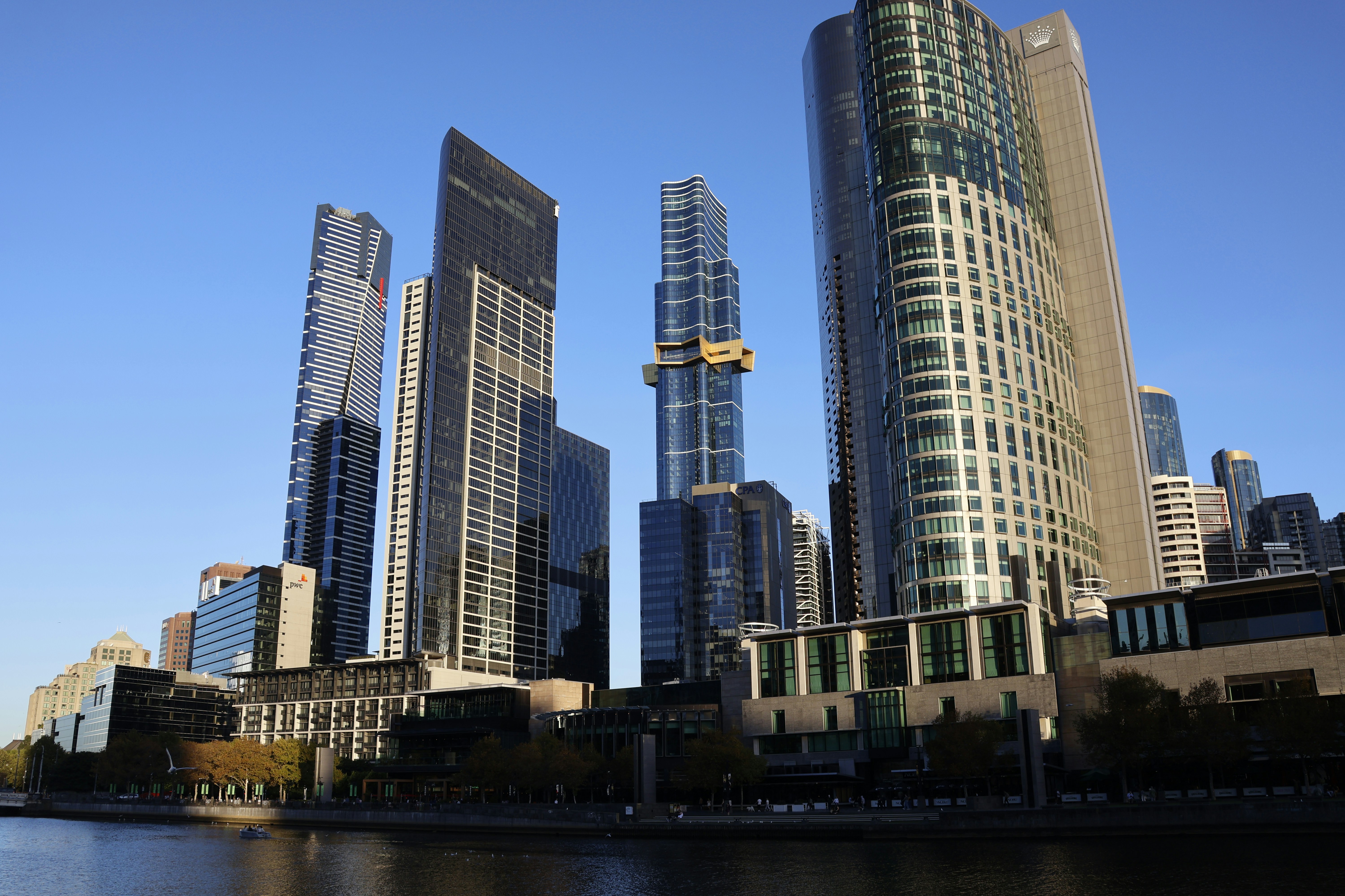 Modern skyscrapers rise against a clear blue sky.