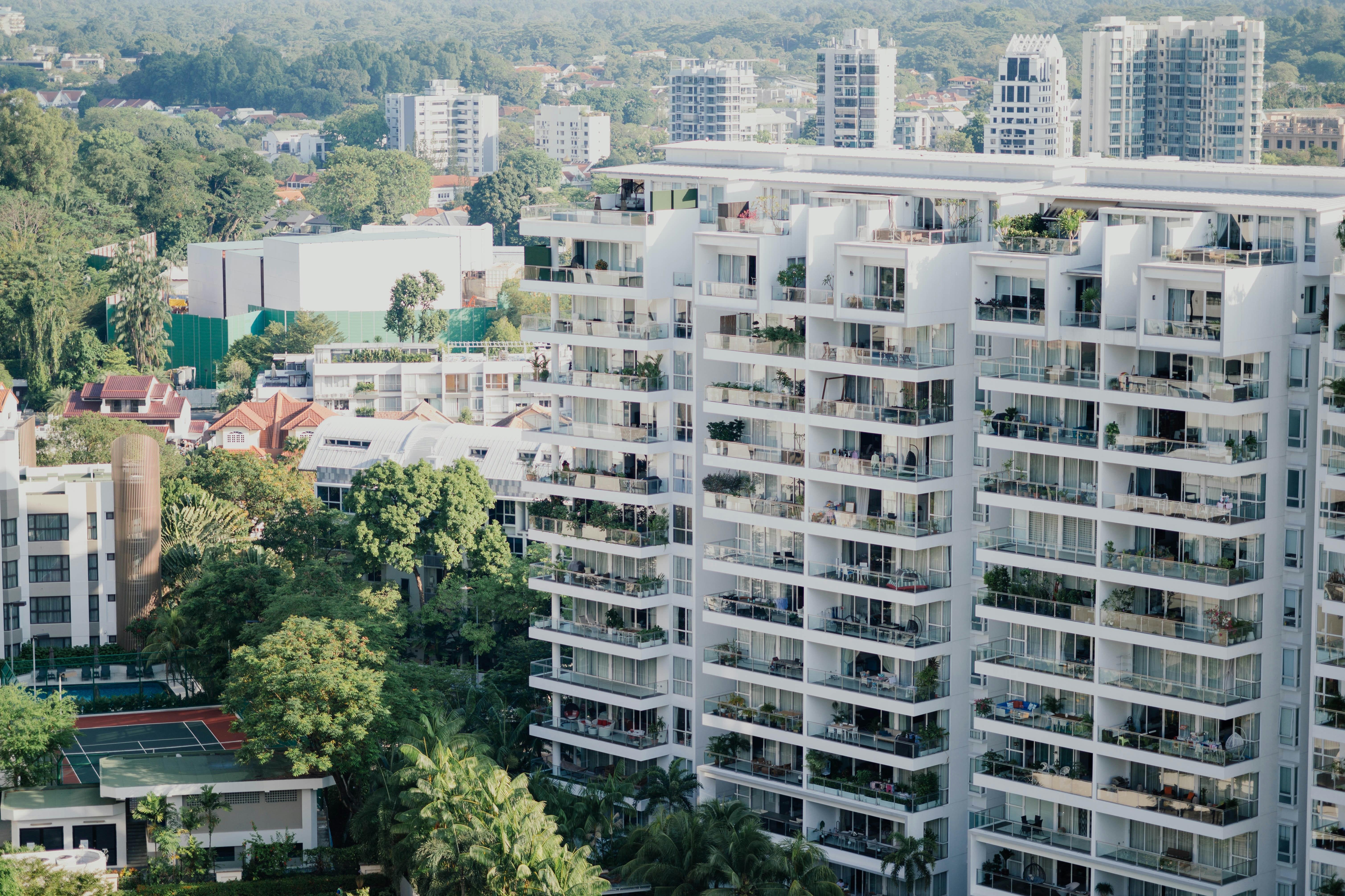 Modern apartment buildings with balconies and trees.