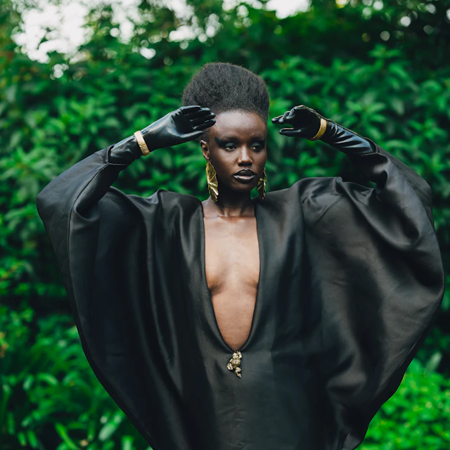 A woman in a black dress with dramatic sleeves