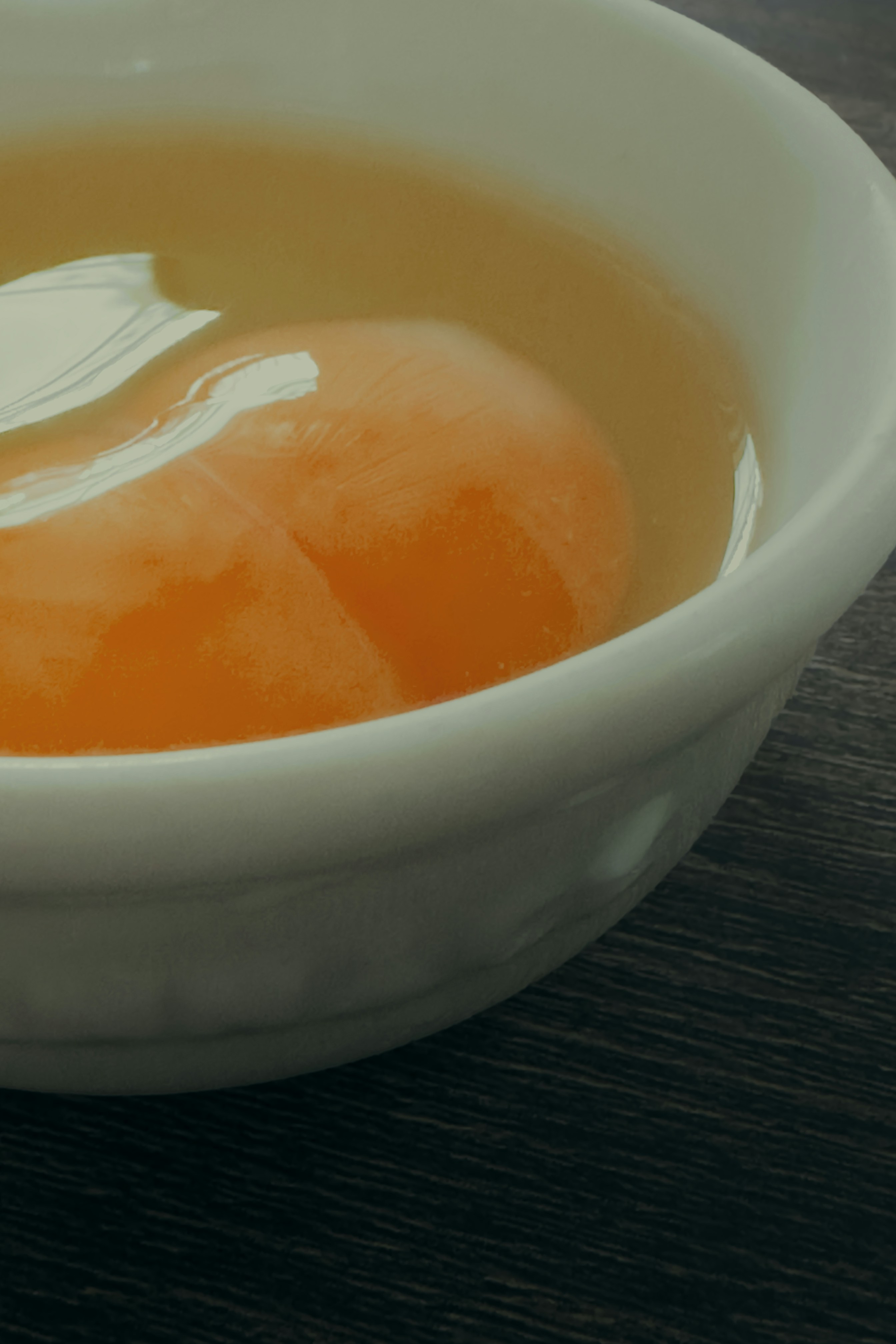 Raw egg yolk and white in a bowl