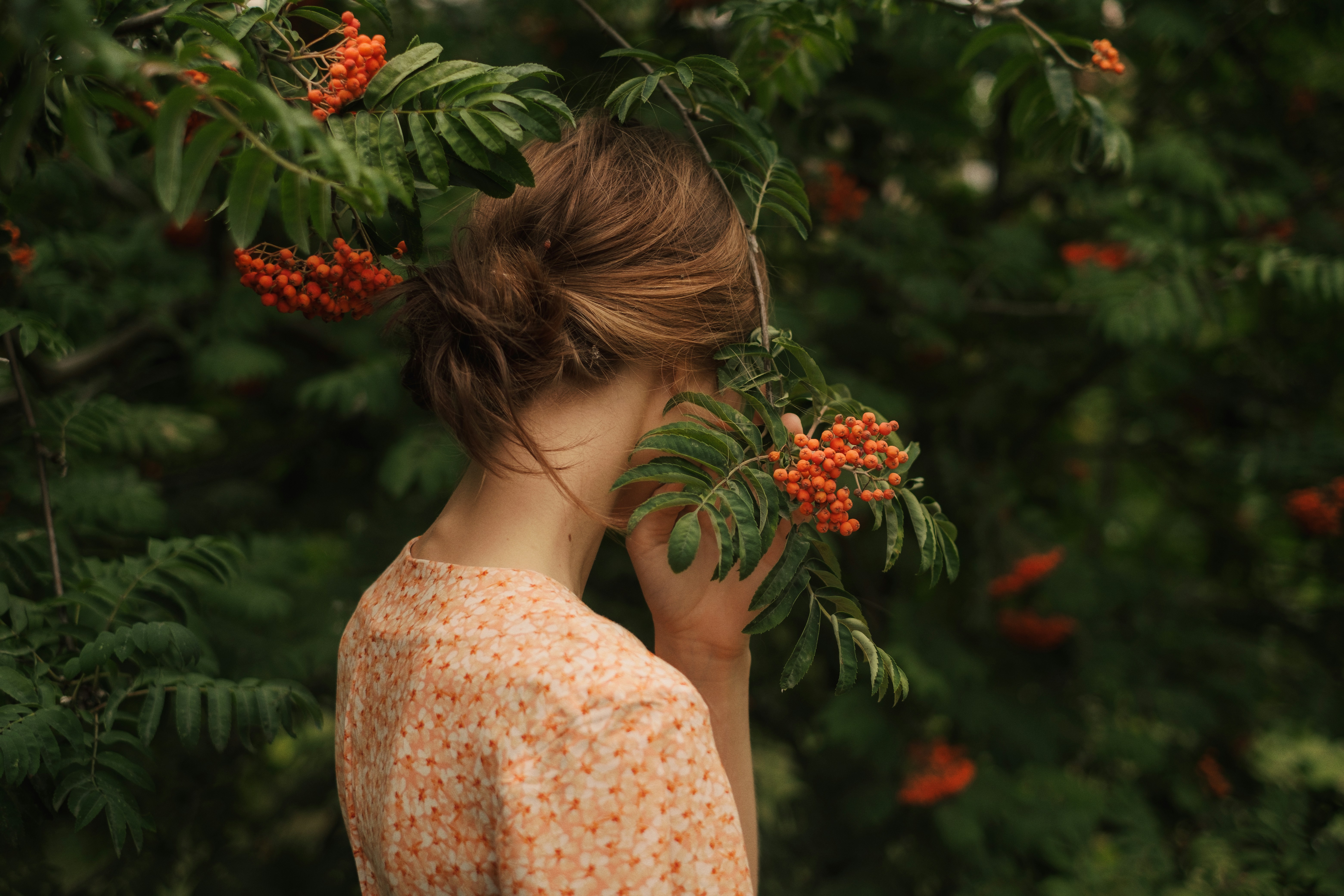 Woman with rowan tree branches covering face