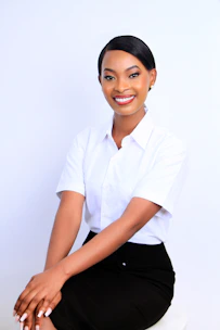 A smiling woman in a white shirt and black skirt