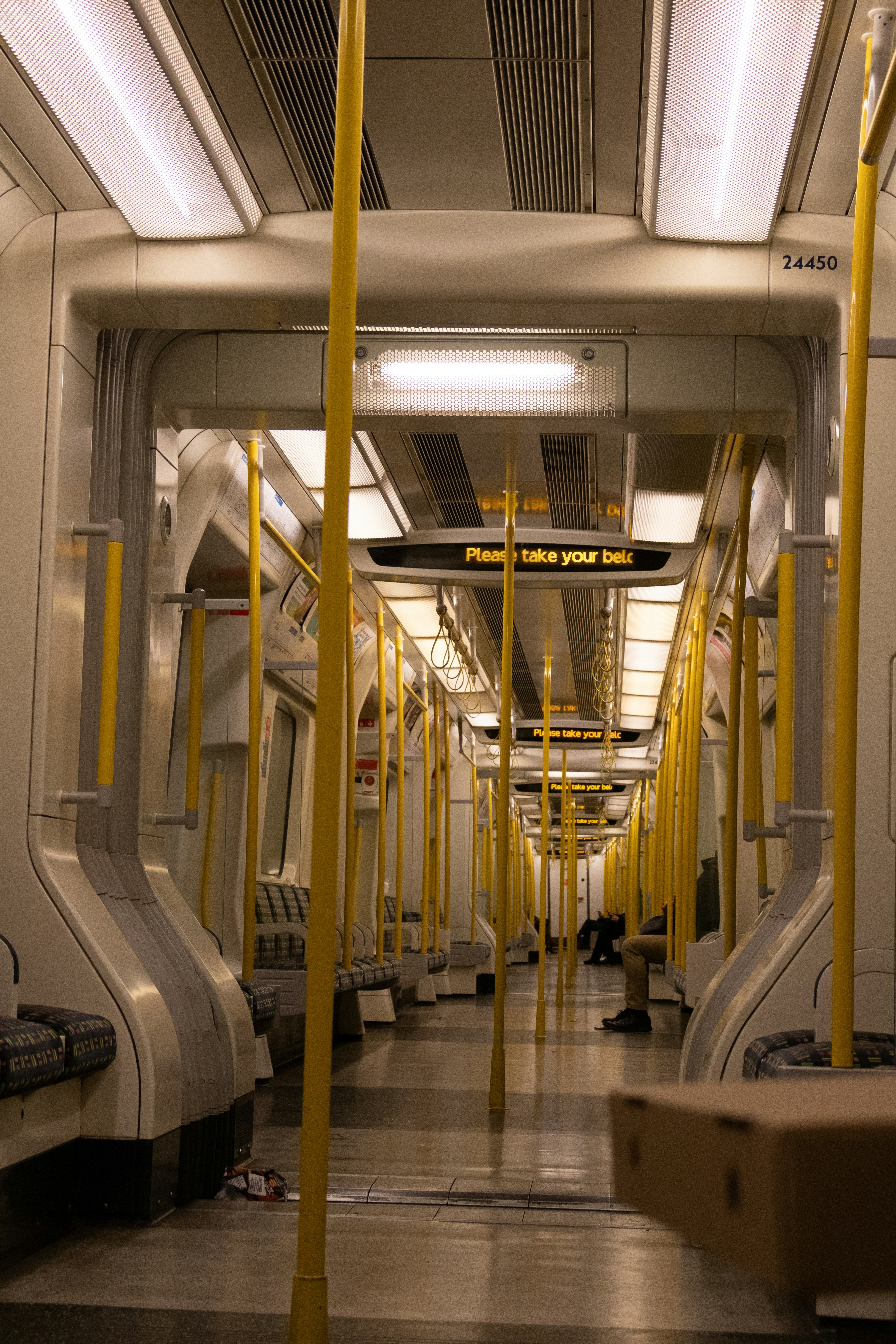Empty subway car with yellow poles and seats