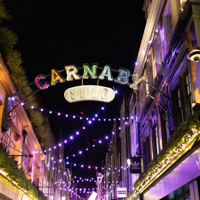 Carnaby Street in London at night, strung with lights