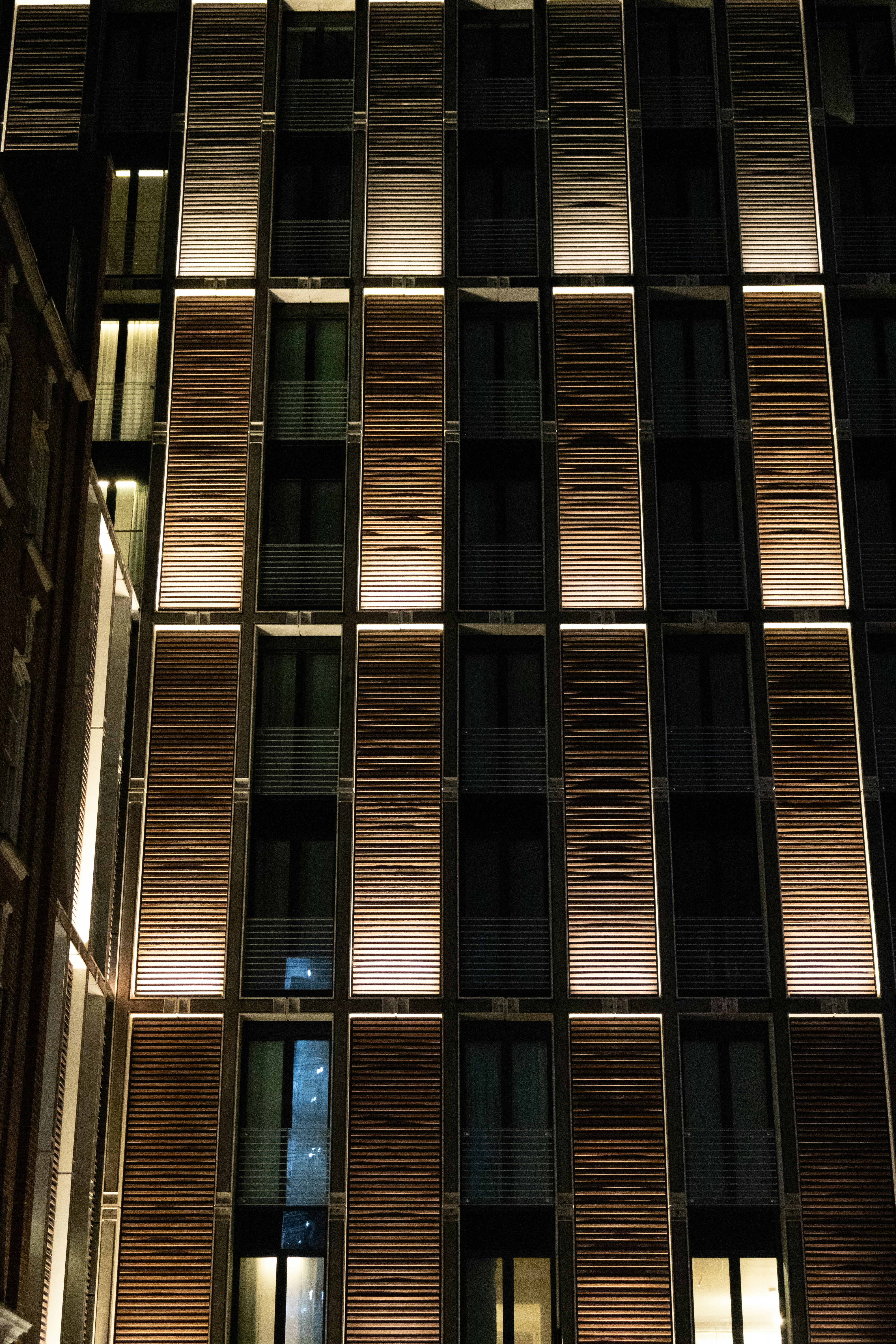 Modern building facade with illuminated windows at night photo – Free ...