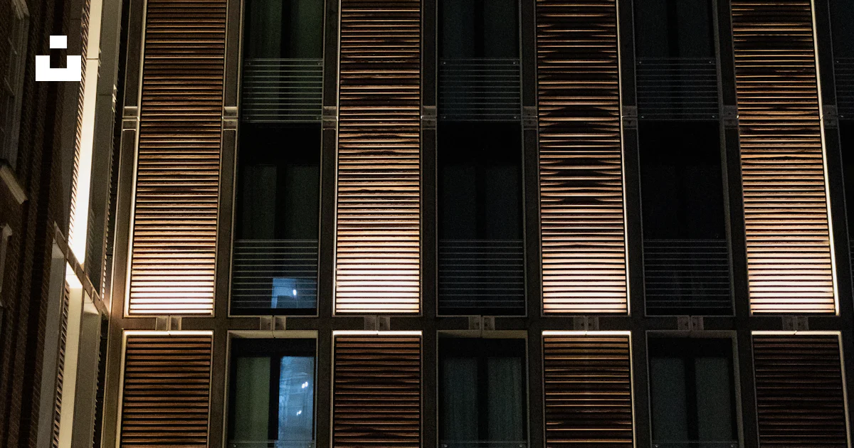 Modern building facade with illuminated windows at night photo – Free ...