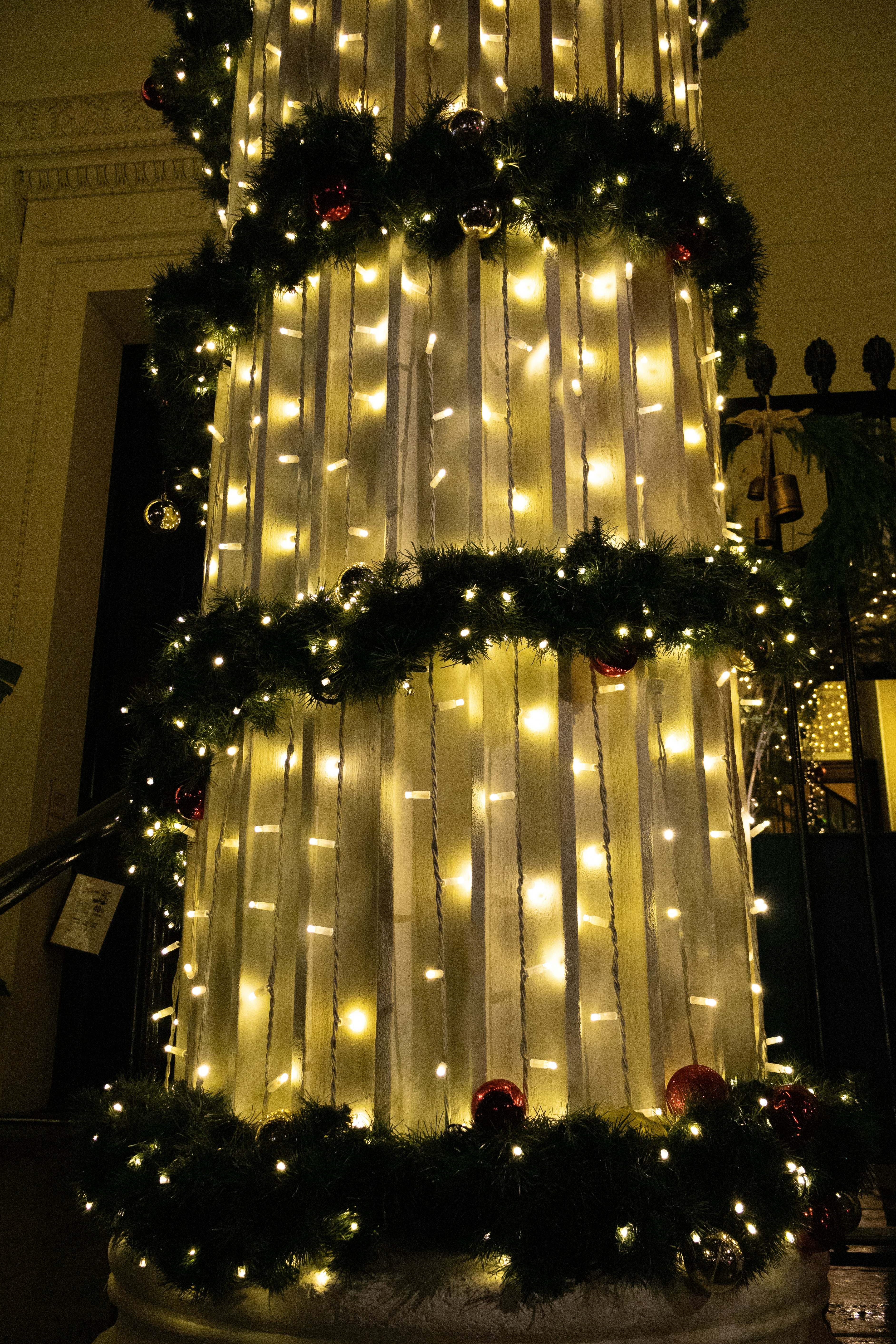 Column decorated with christmas lights and garland