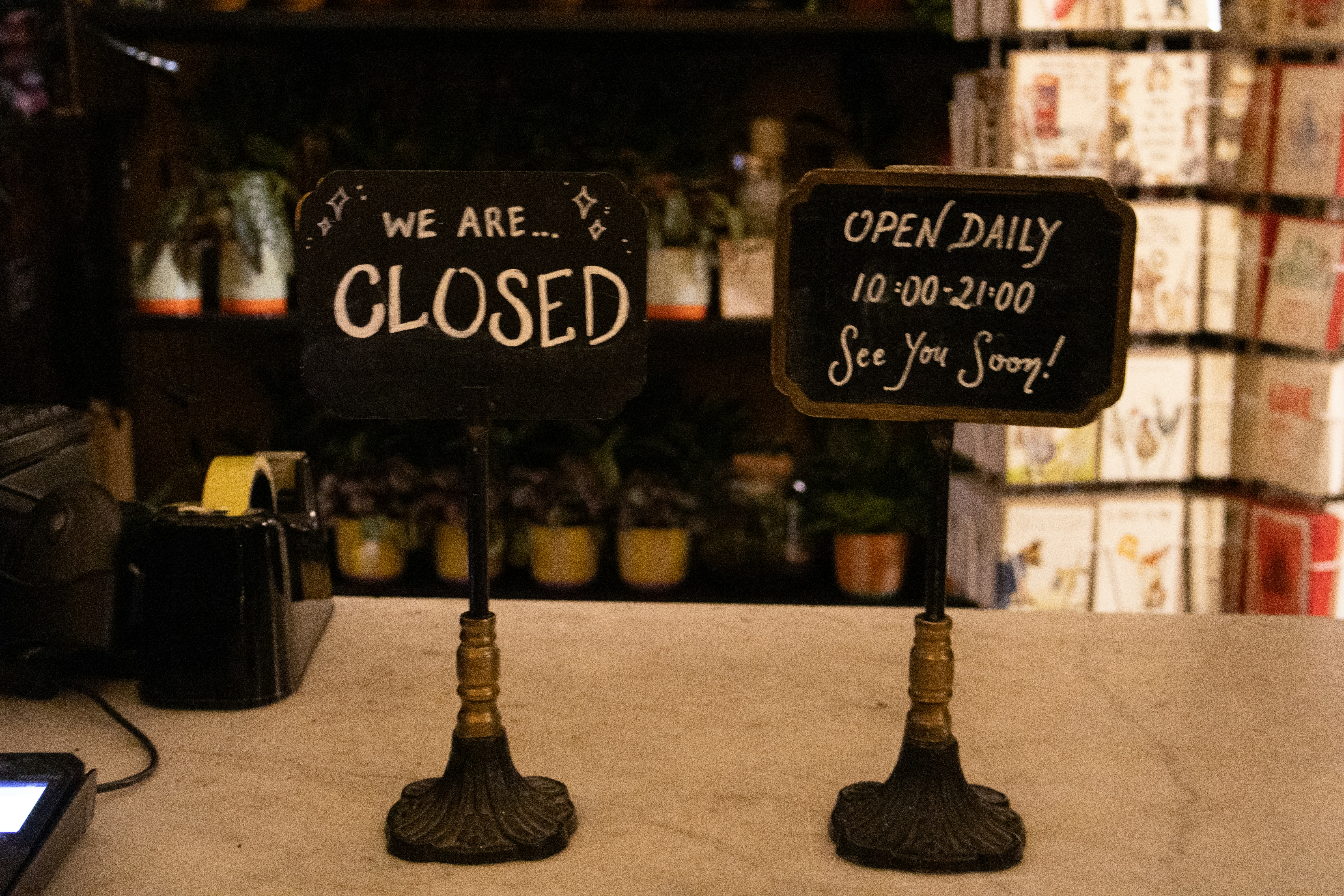 Two signs, one closed, one open daily.