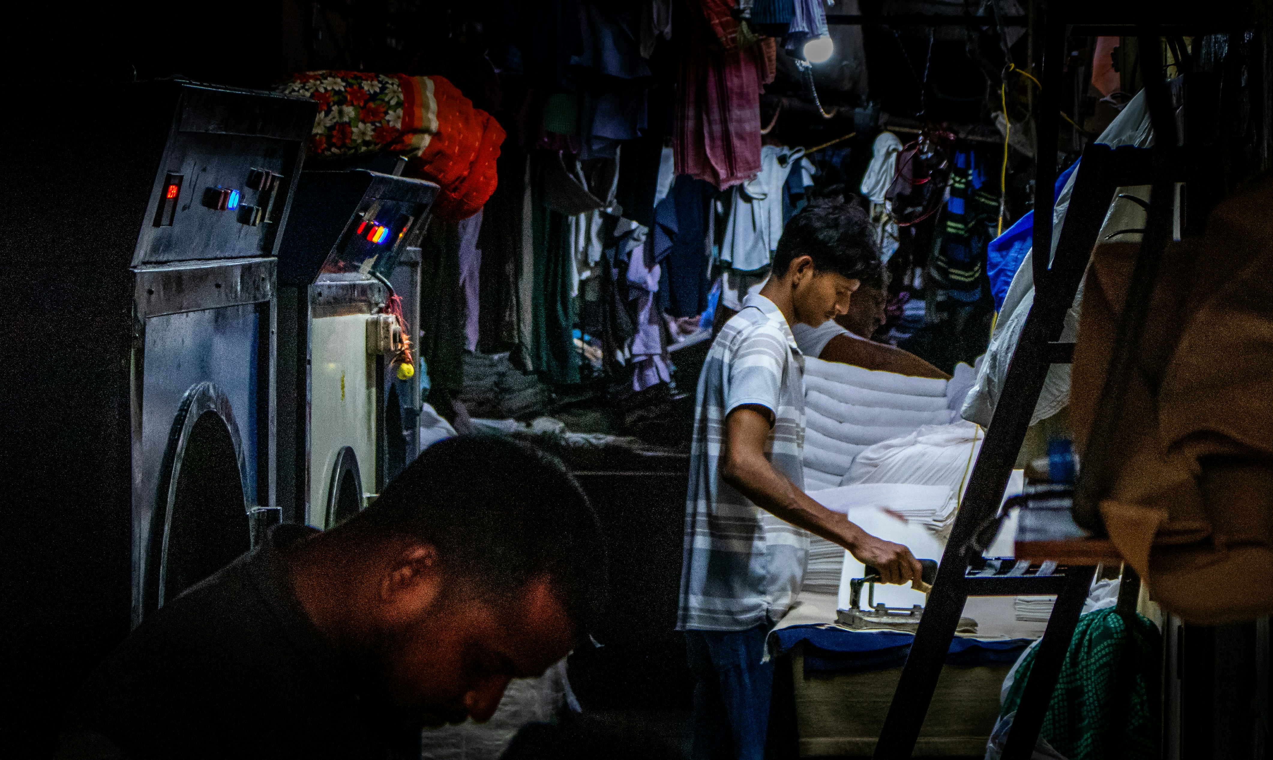 Young man ironing white linens