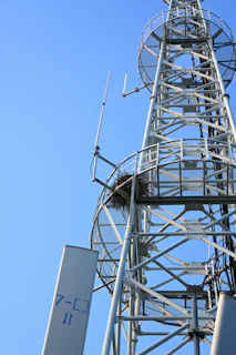 Tall metal tower with antennas against clear blue sky
