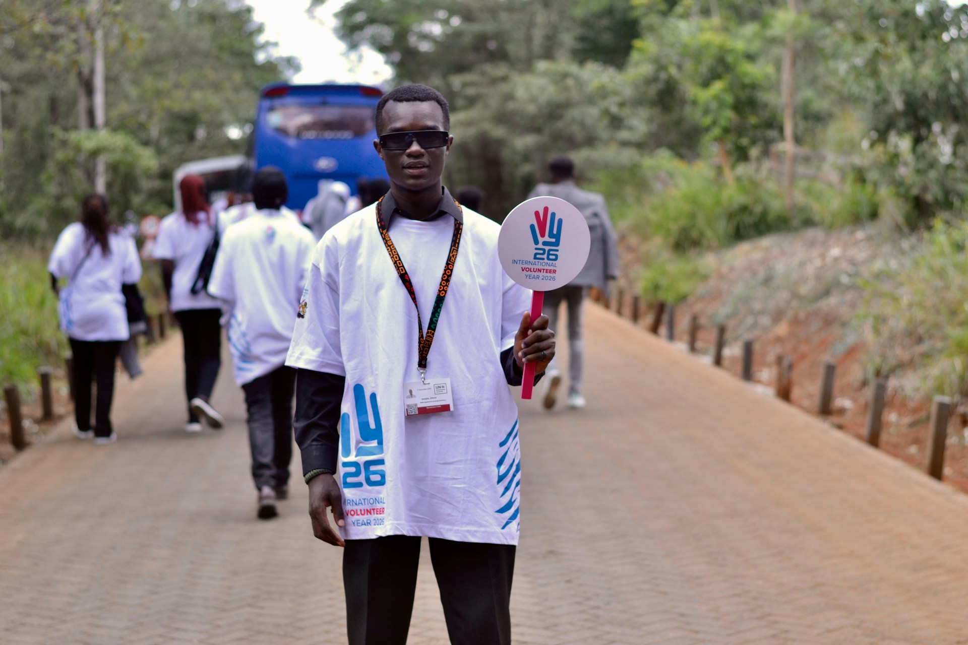 Man in white shirt holding a sign outdoors