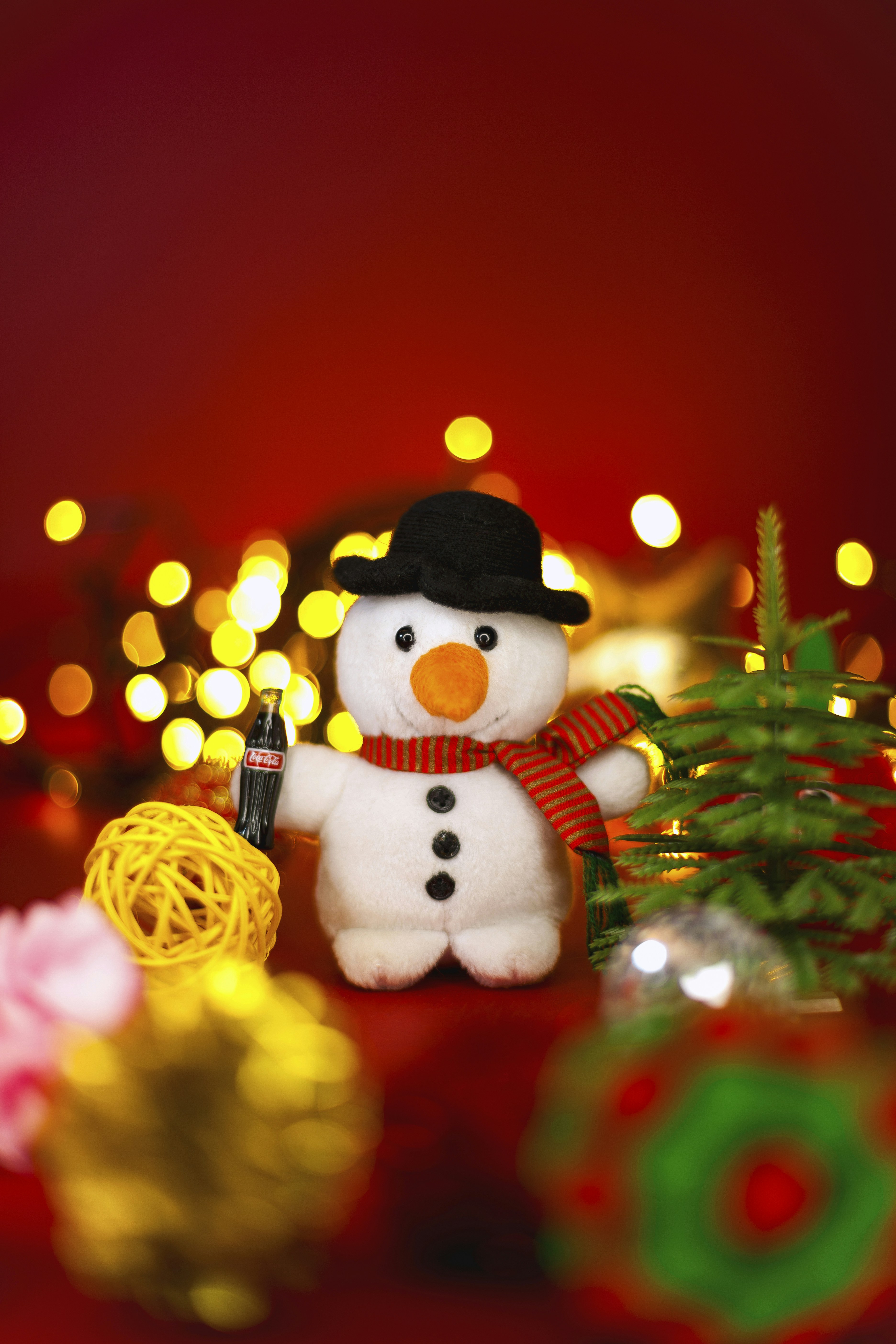 コカ・コーラのボトルとクリスマスの飾りがついたぬいぐるみの雪だるま