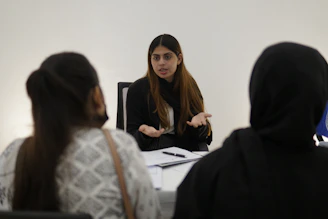 Woman gesturing while talking to two people