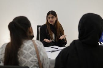 Woman gesturing while talking to two people