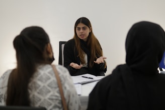 Woman gesturing while talking to two people