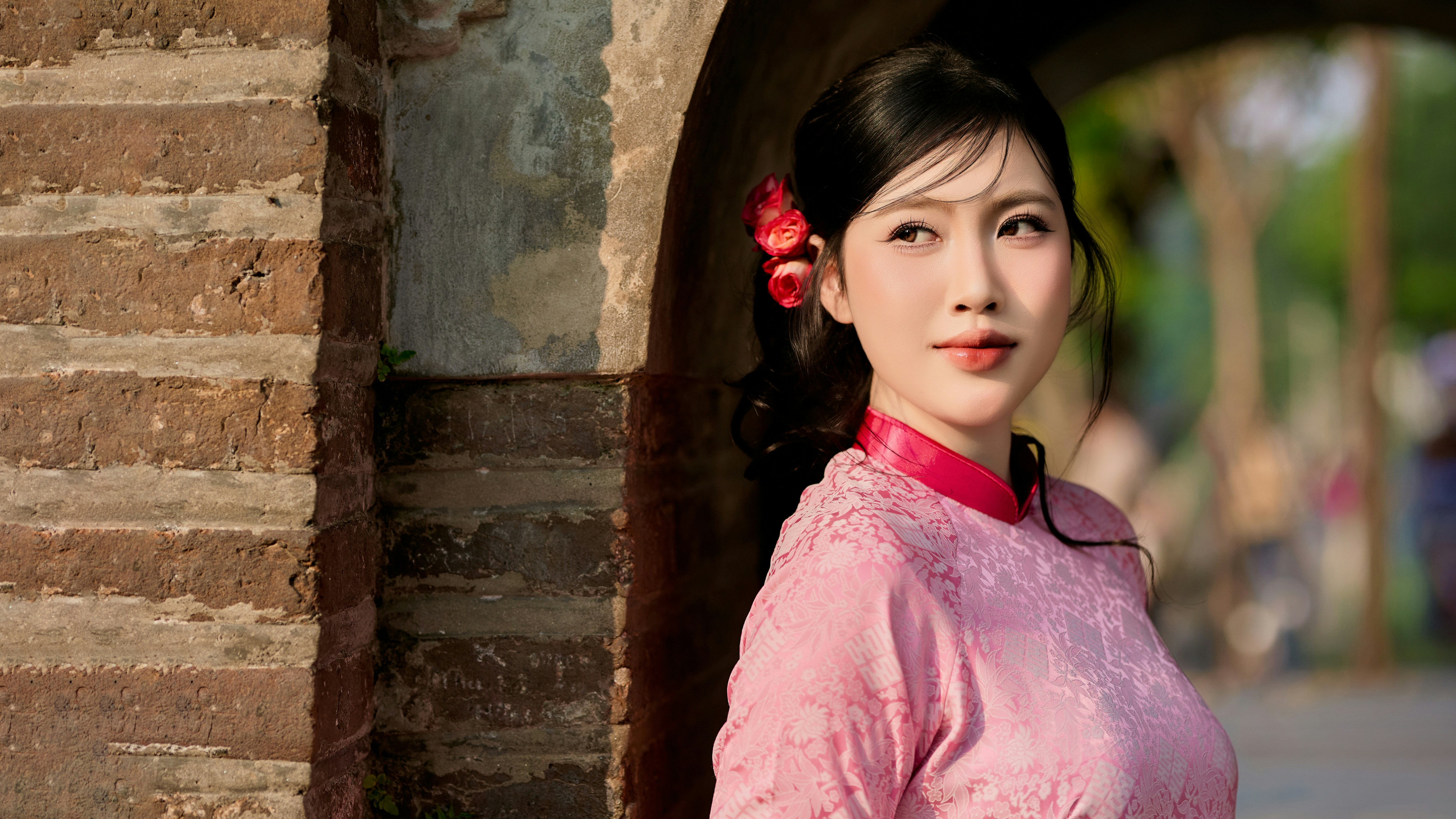 Young woman in pink traditional dress looks away
