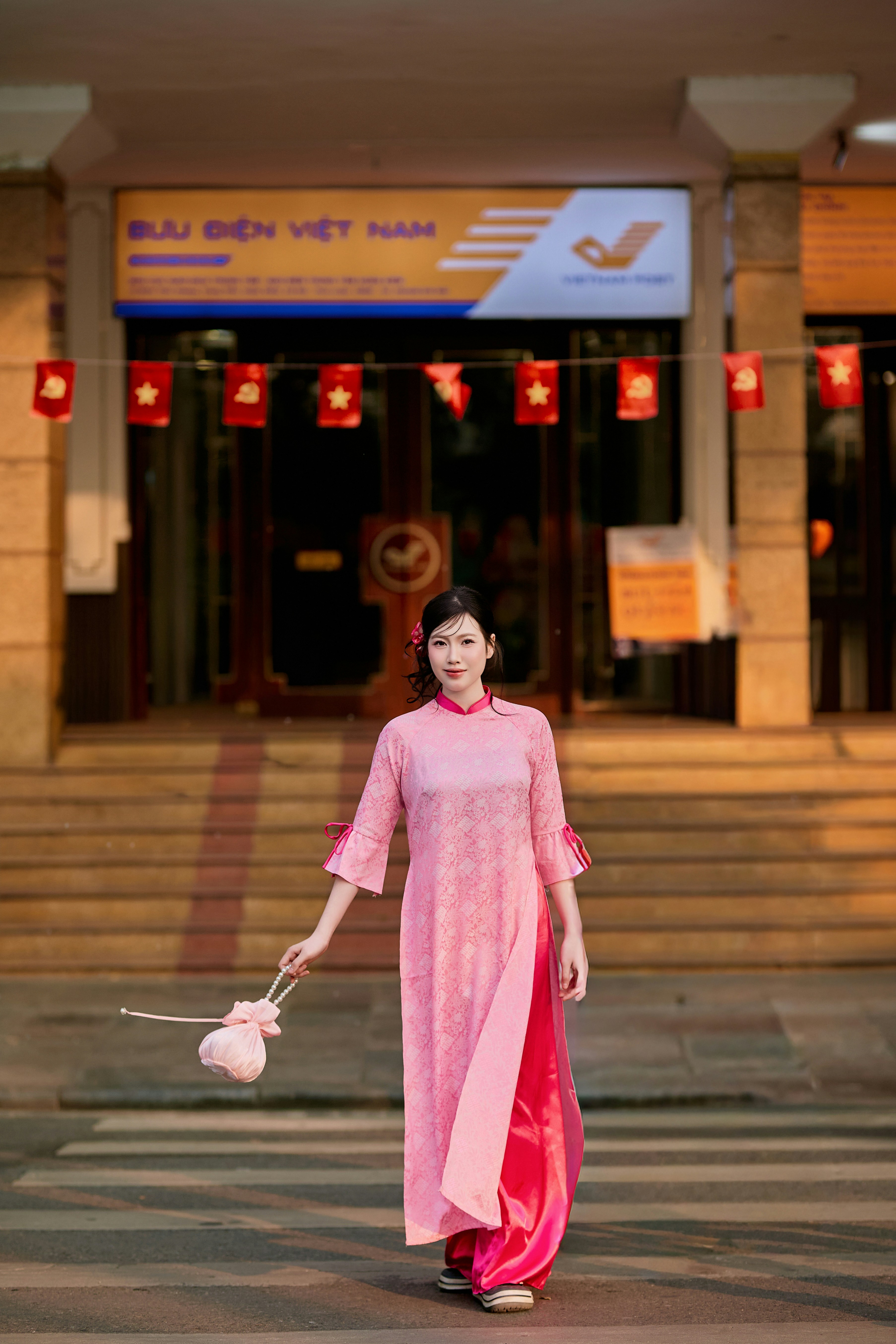Woman in pink traditional dress in front of post office