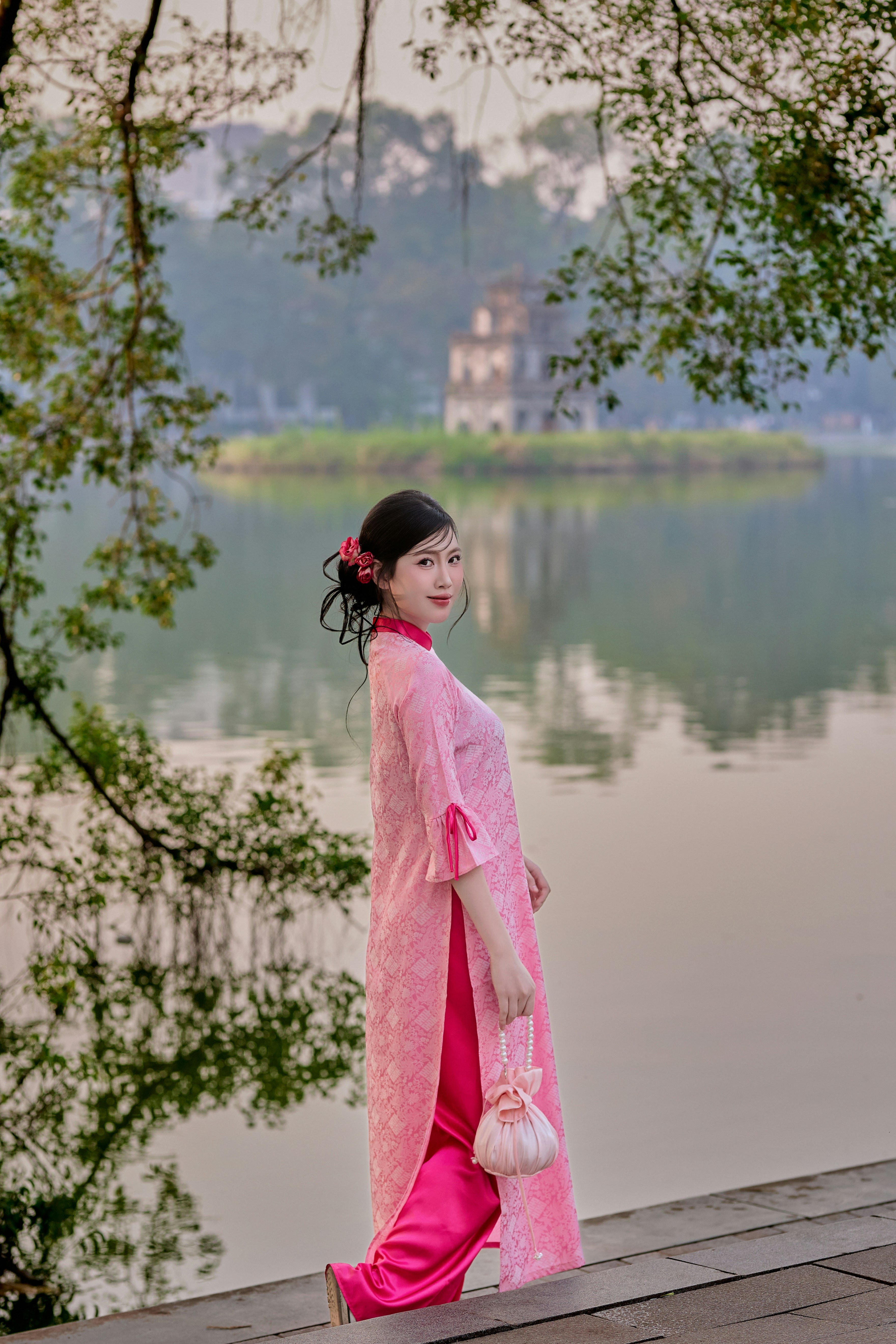 Woman in pink traditional dress by a lake