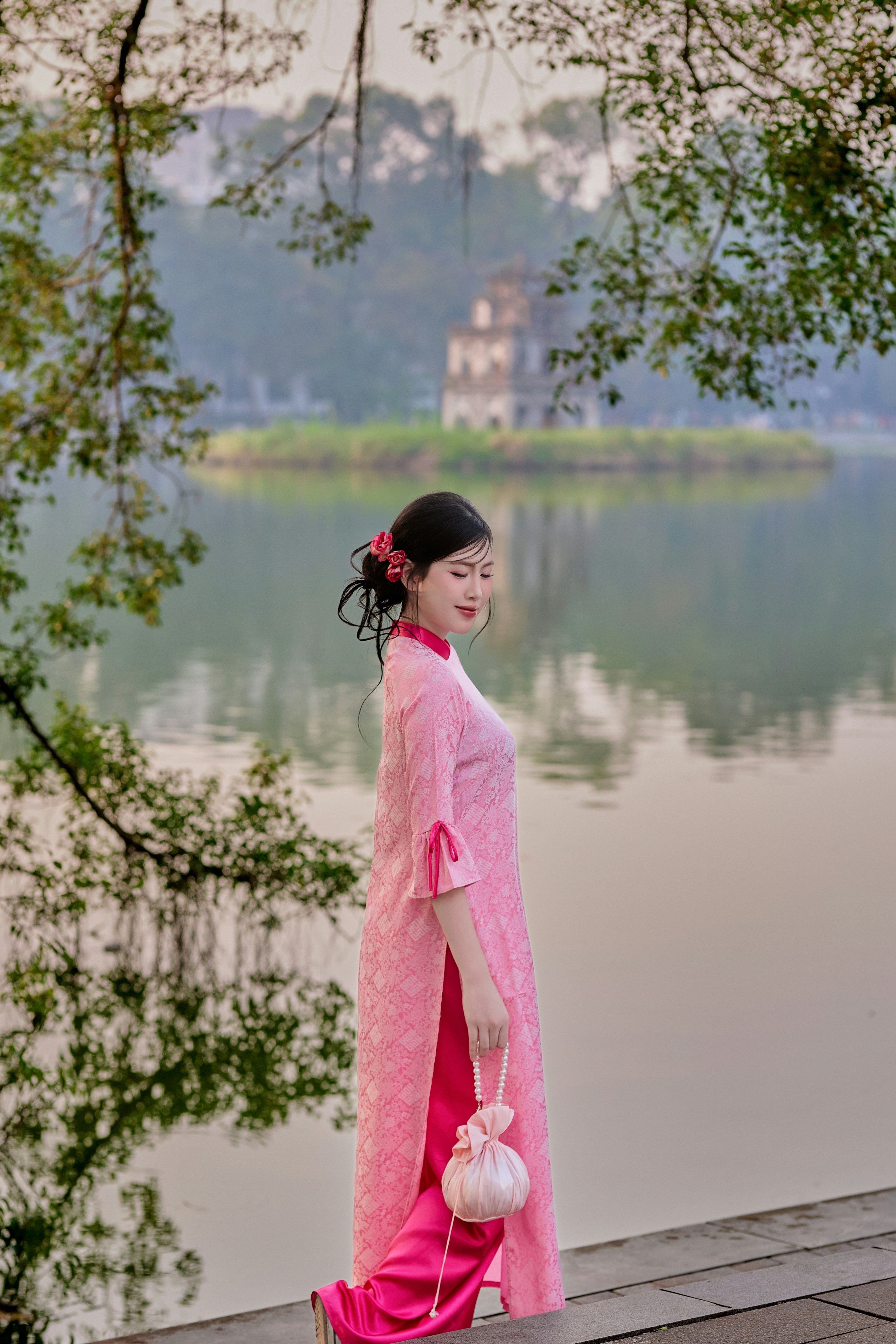 Woman in pink traditional dress by a lake