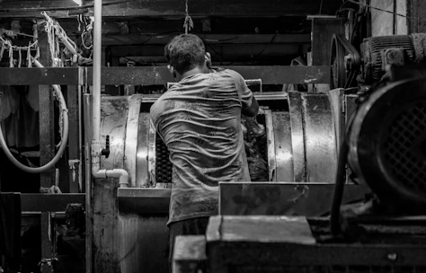 Man working in a dark, industrial factory setting.
