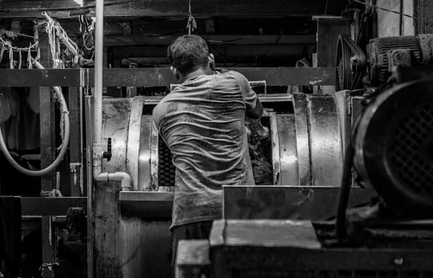 Man working in a dark, industrial factory setting.