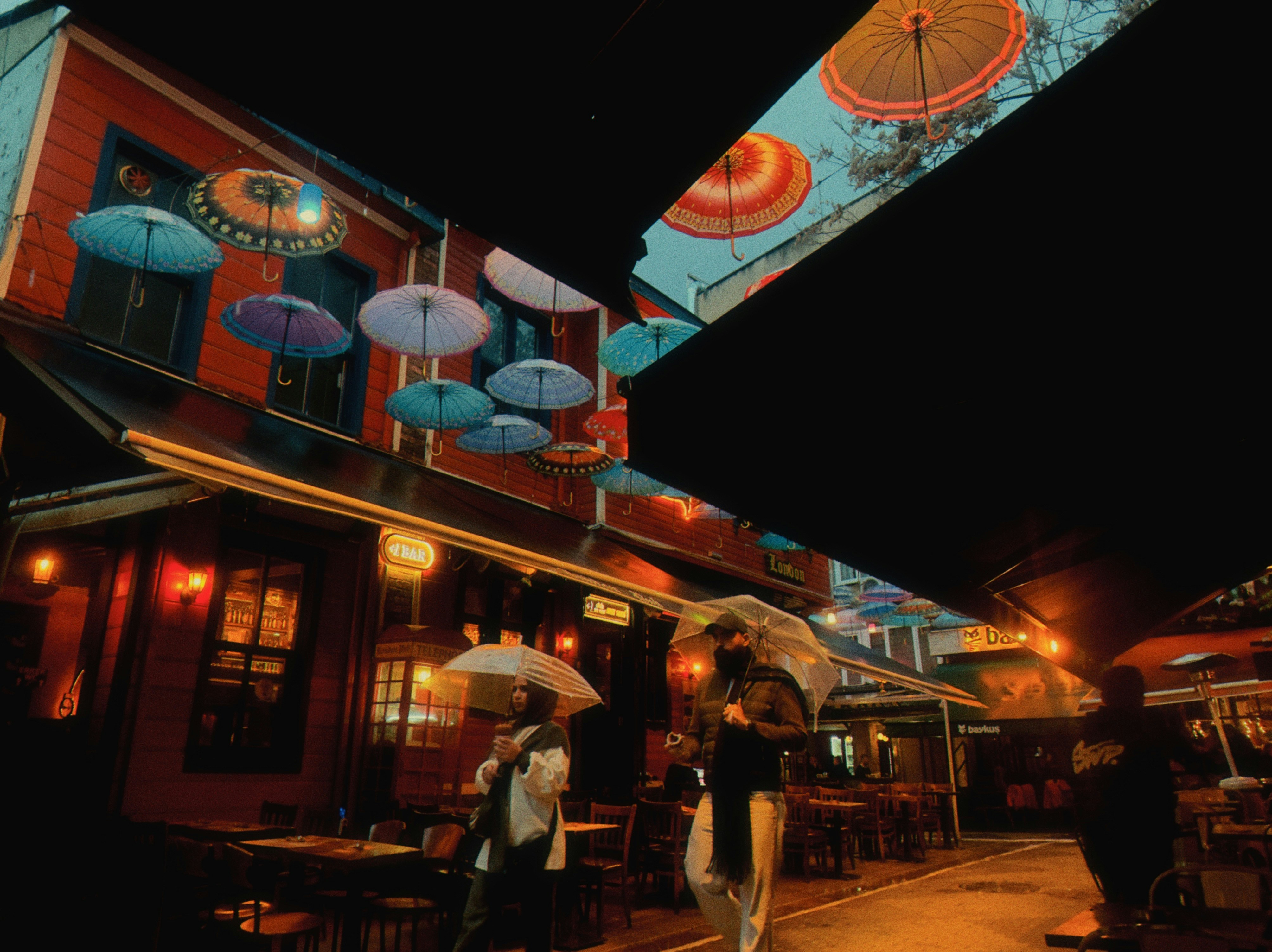 Colorful umbrellas decorate a street at night.
