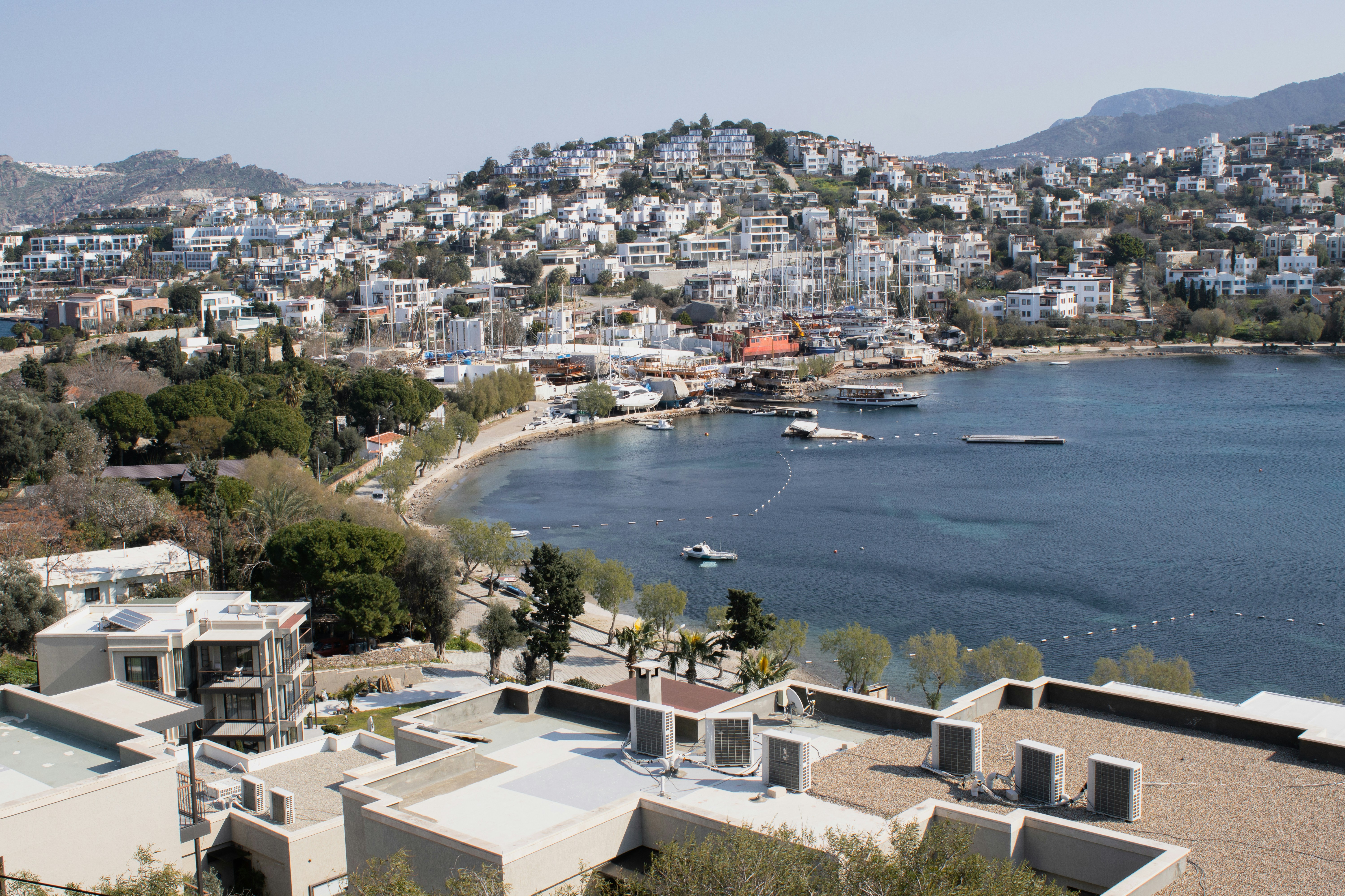 Coastal town with white buildings overlooking blue bay.