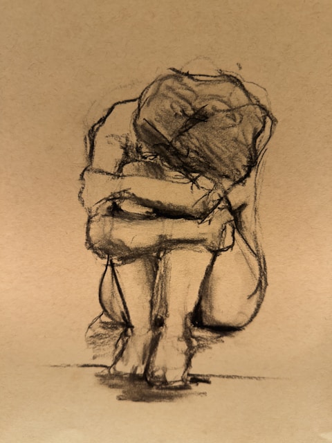 A charcoal sketch of a person curled up.