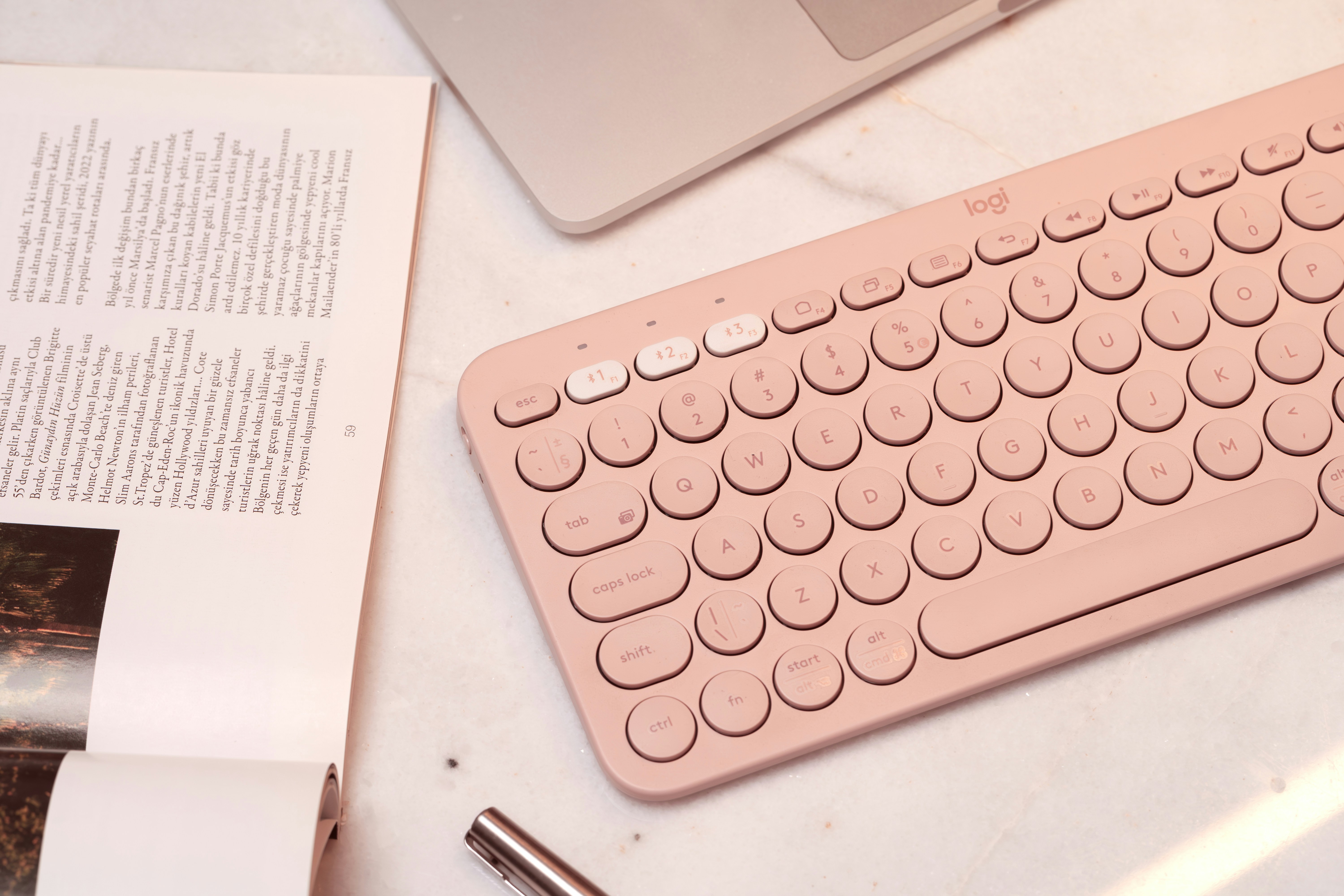 Pink keyboard and laptop on a desk