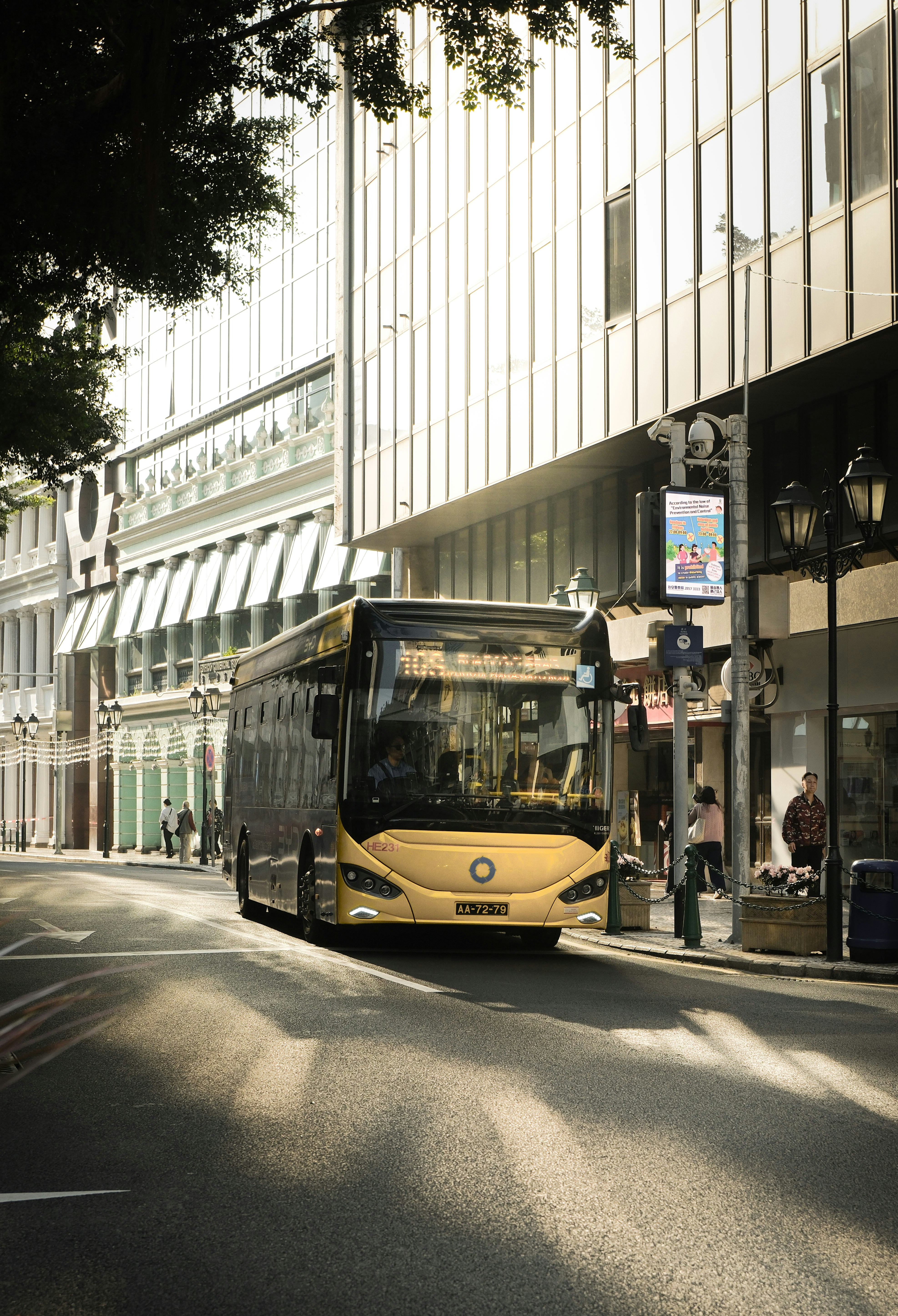 A yellow bus drives down a city street.