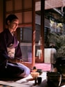 Woman in kimono performs traditional tea ceremony.