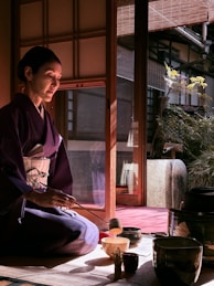 Woman in kimono performs traditional tea ceremony.
