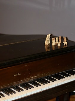 Small wooden figures on a grand piano