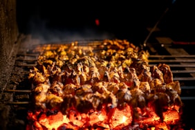 Meat skewers cooking over glowing hot coals