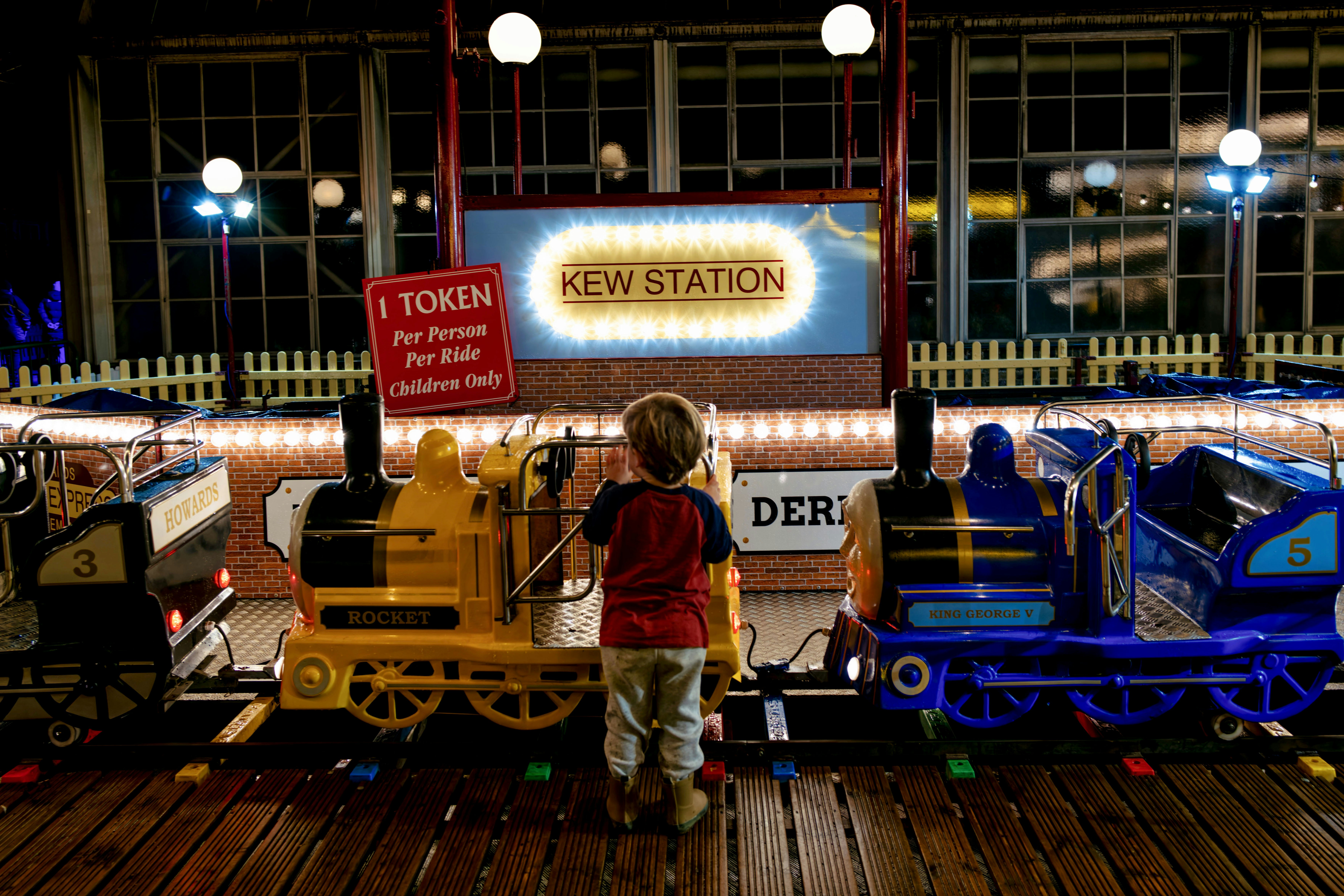 Un enfant regarde des trains miniatures à la gare