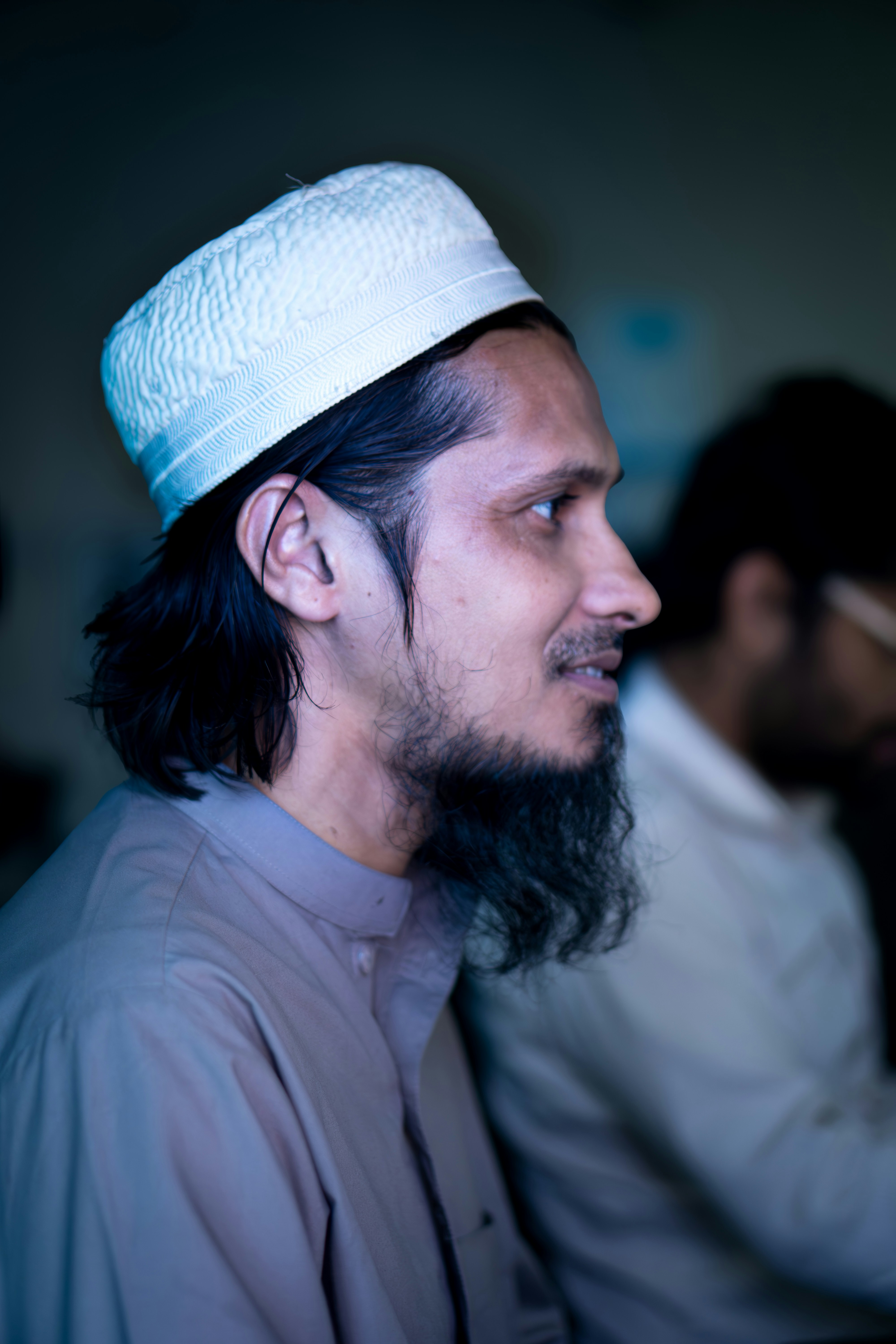Man wearing a white kufi cap and beard
