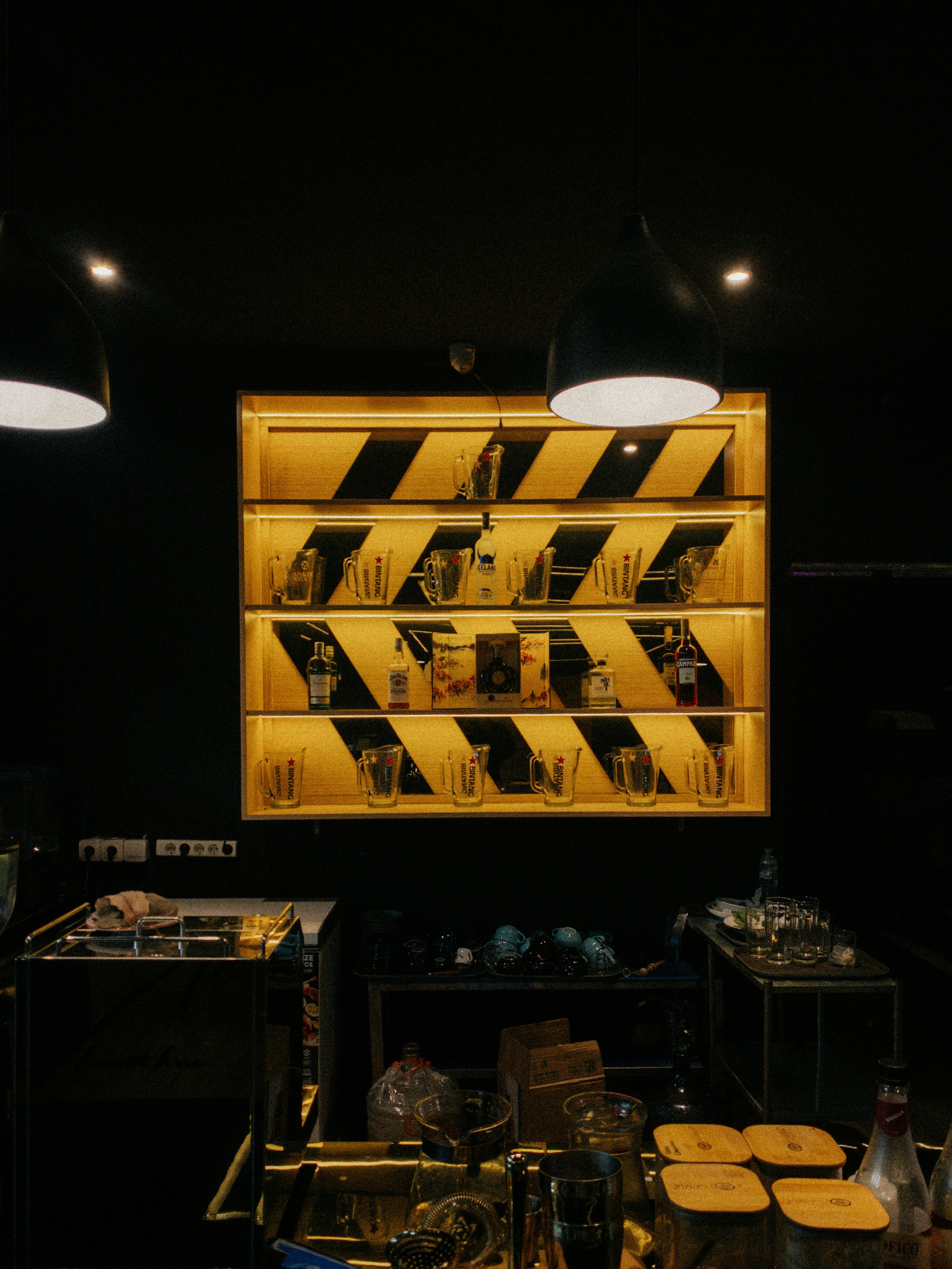 Barista station with illuminated shelves of glassware.