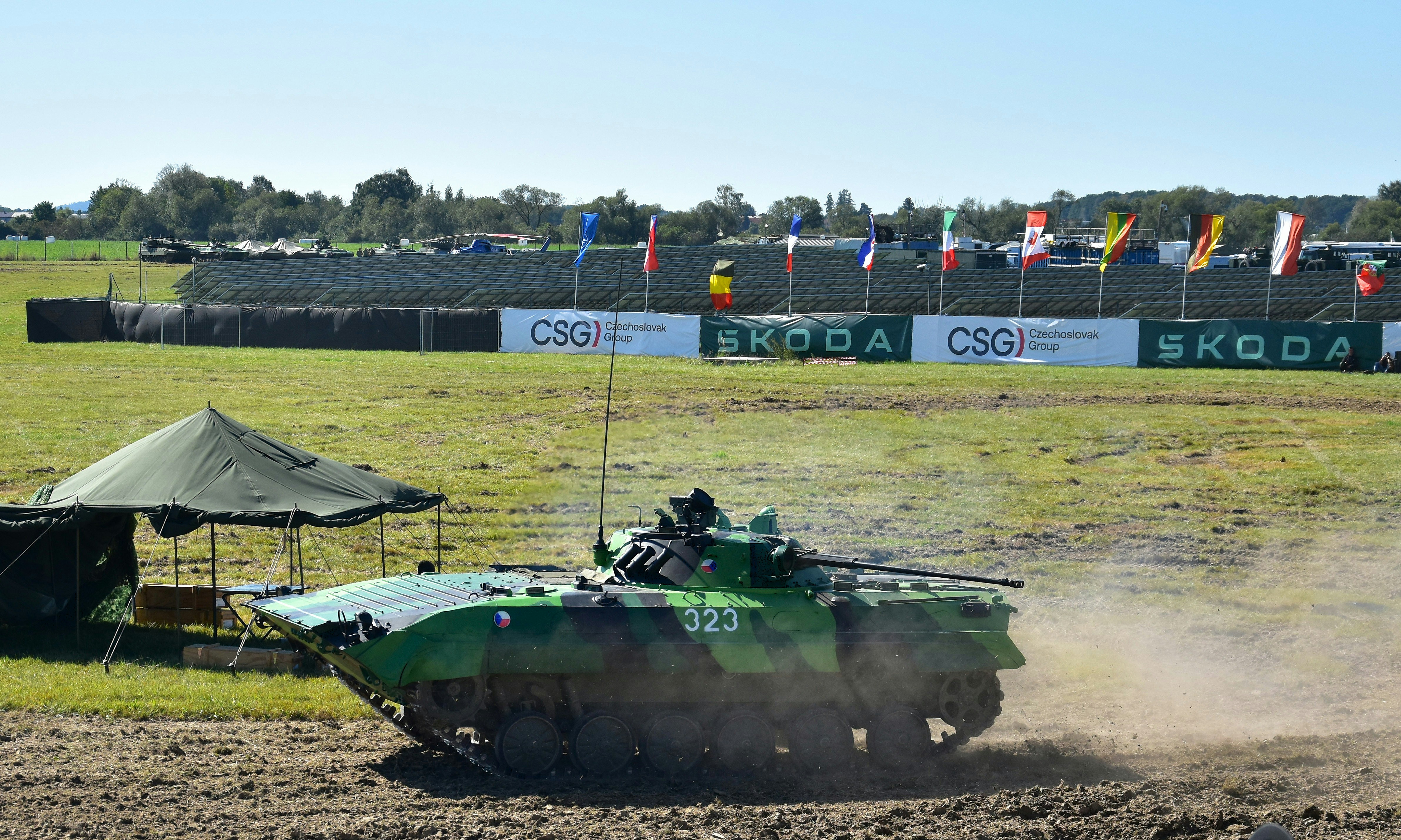 Armored personnel carrier driving on dusty terrain