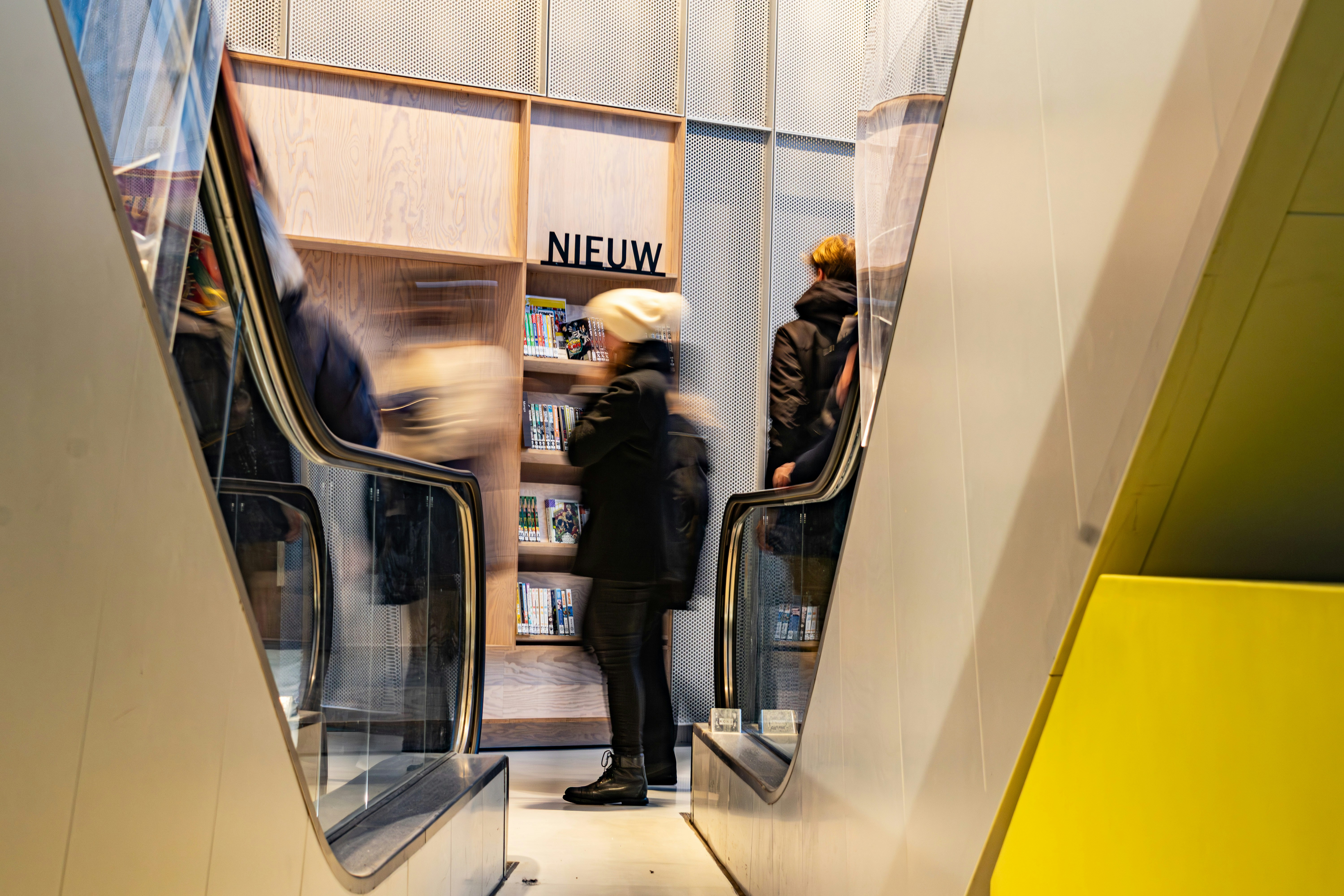 People on escalators in a modern store.