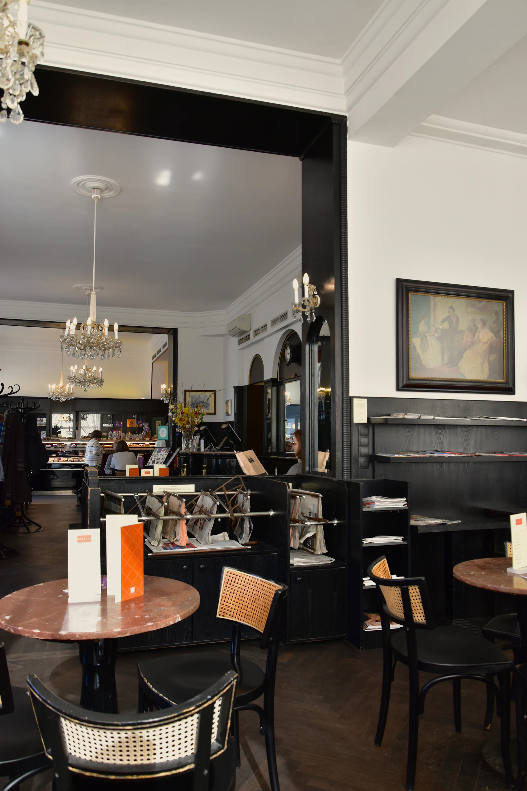 An elegant traditional Vienna coffee-house interior with marble tables and upholstered seating